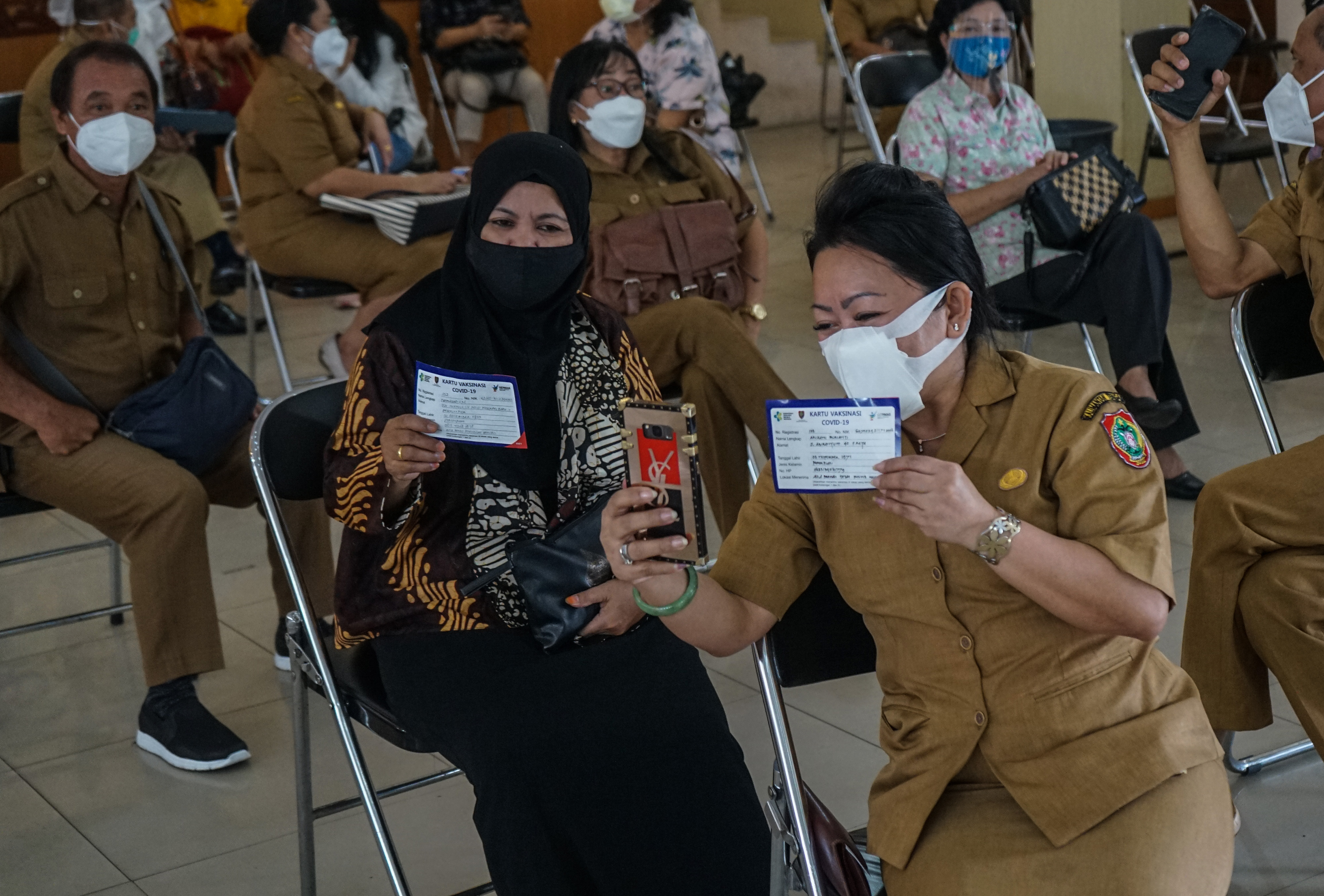 Sejumlah guru berswafoto usai divaksin Covid-19 di Aula Dinas Pendidikan Provinsi Kalteng, Palangkaraya, Kalteng, Selasa (6/4).