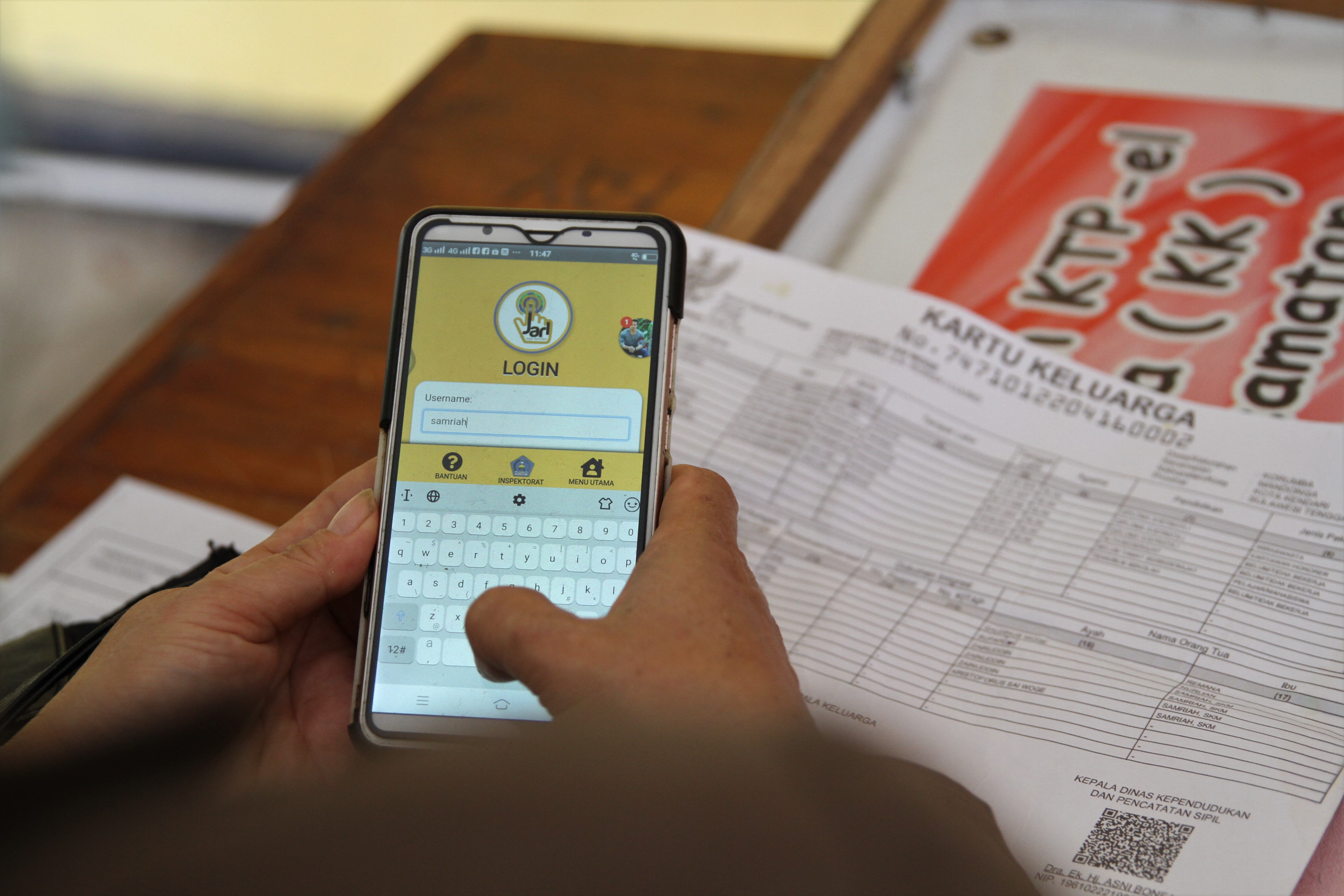 APLIKASI: Warga melakukan registrasi melalui handphone dengan aplikasi Jaga Kendari (Jari) di Kantor Disdukcapil Kota Kendari, Sultra.
