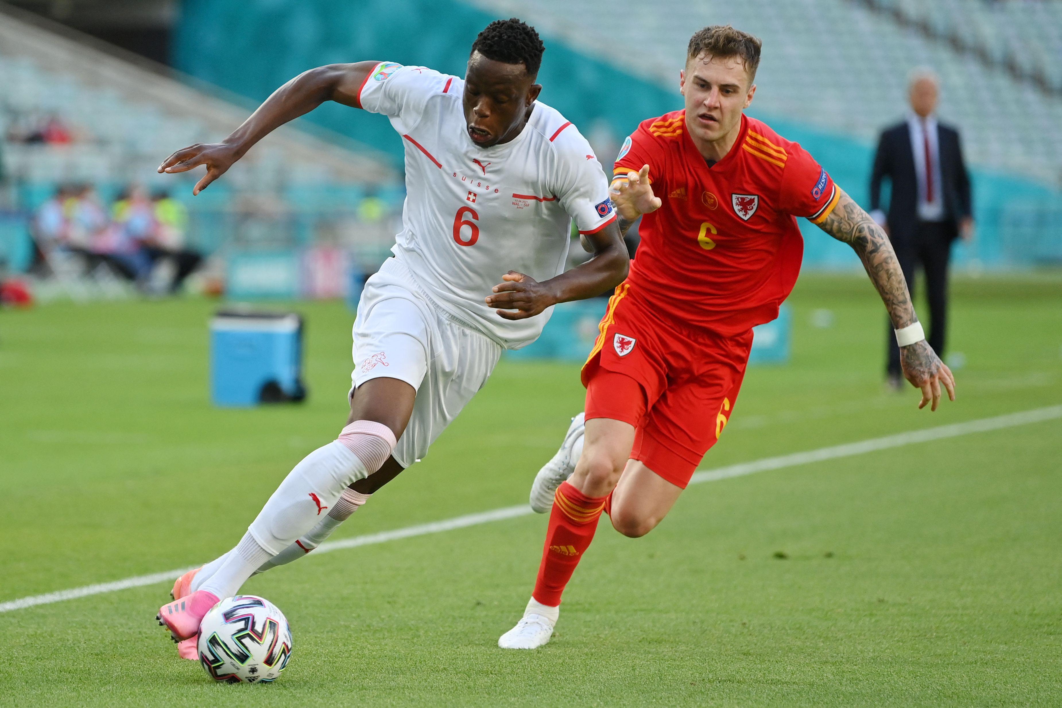 Bek Wales Joe Rodon (kanan) mengawal gelandang Swiss Denis Zakaria di laga Piala Eropa 2020.
