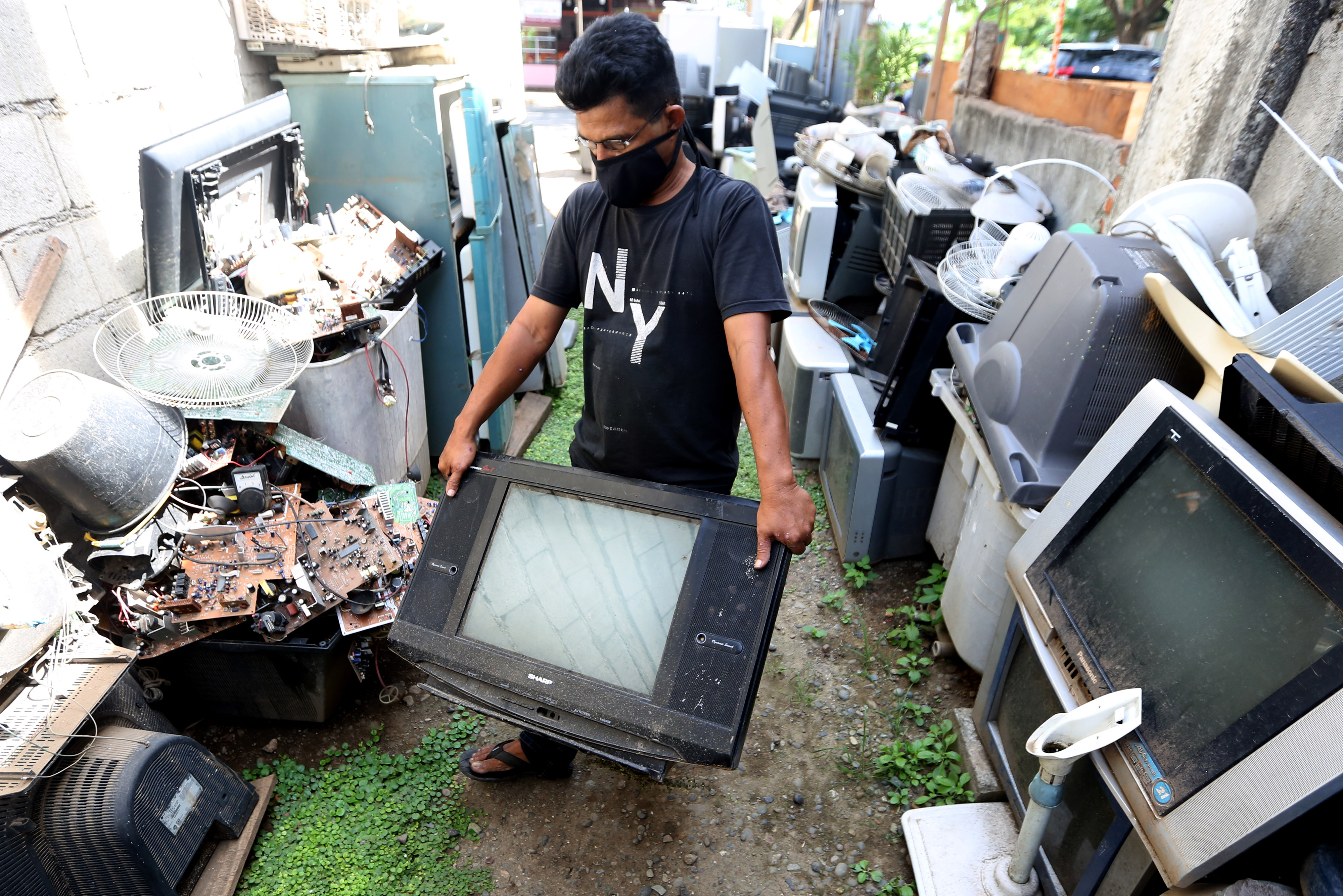 Seorang warga mengumpulkan sampah elektronik untuk mengambil komponen yang masih bisa digunakan