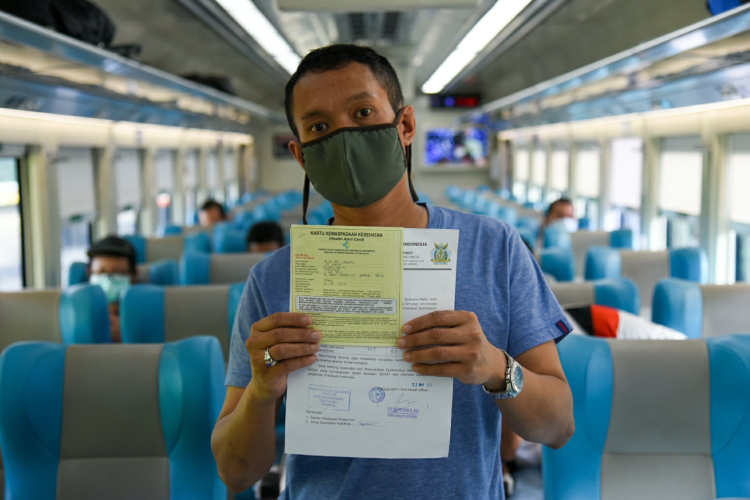 Salah satu calon penumpang kereta api jarak jauh menunjukkan surat sahat bebas covid-19.