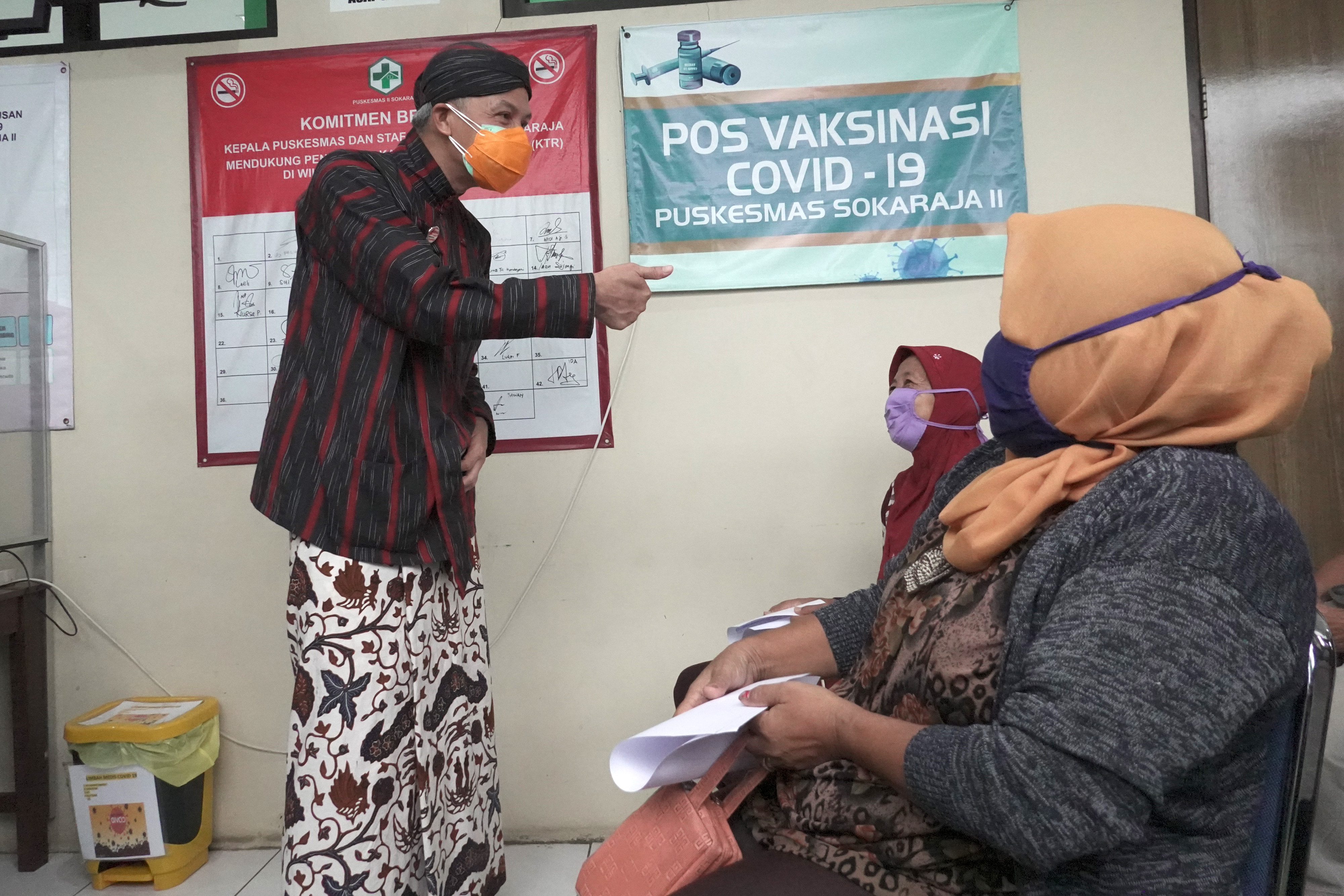 Gubernur Jateng Ganjar Pranowo (kiri), berbincang dengan peserta program vaksinasi Covid-19 di Puskesmas II Sokaraja, Banyumas, Jateng.