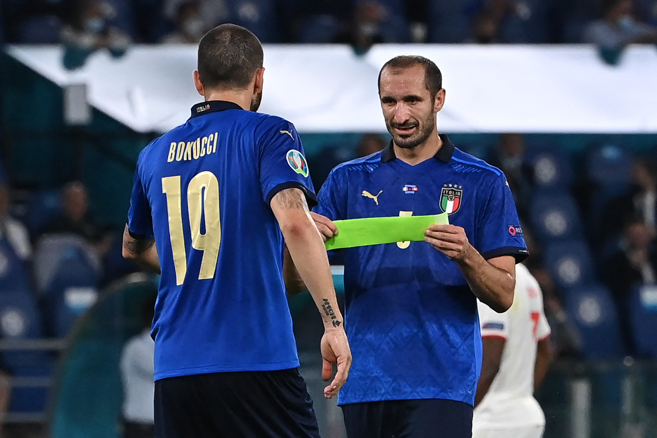 Bek Italia Giorgio Chiellini (kanan) menyerahkan ban kapten kepada Leonardo Bonucci saat ditarik ke luar karena cedera.