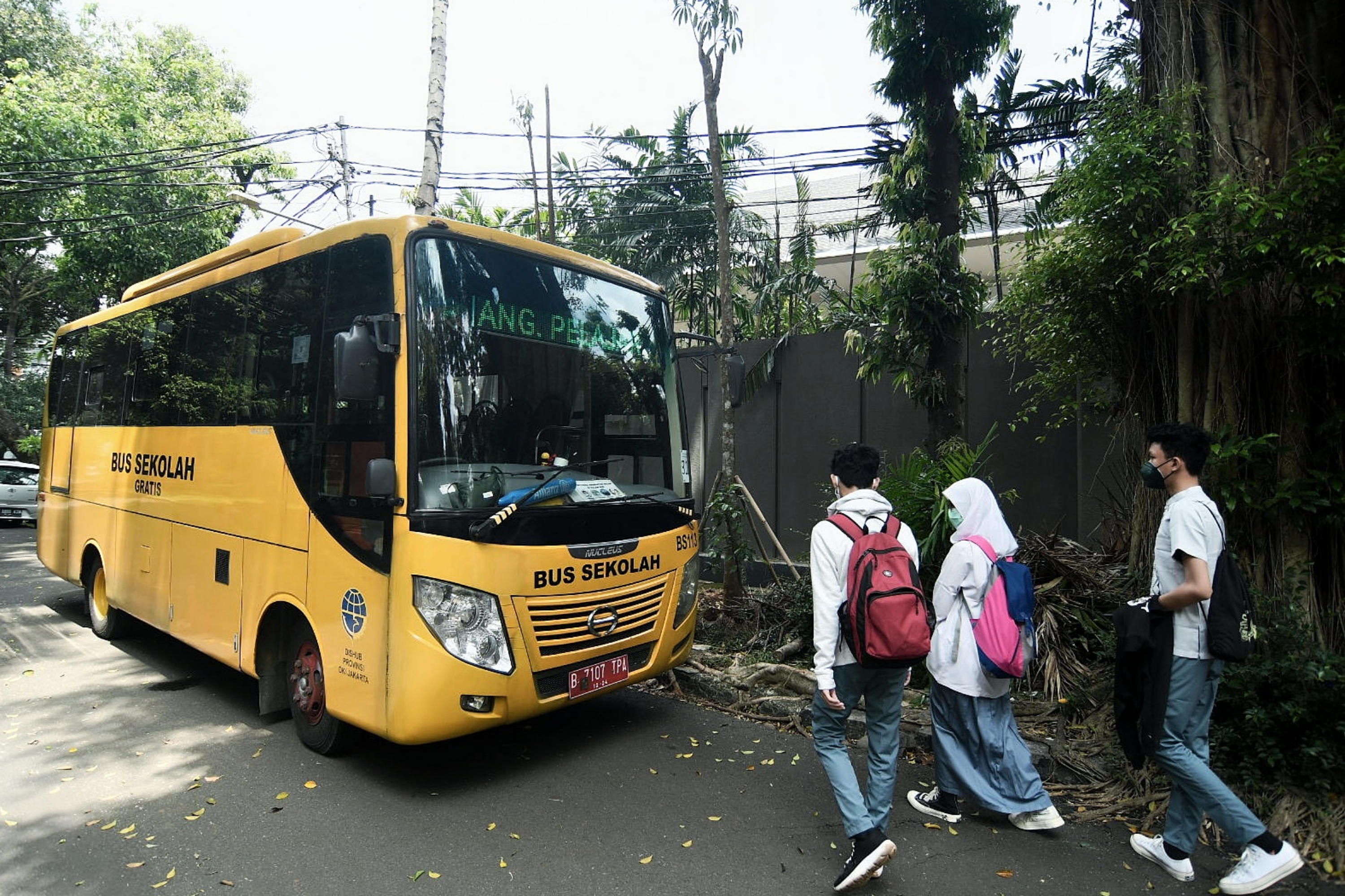 Pelajar menaiki bus sekolah selama uji coba pembelajaran tatap muka di Jakarta.