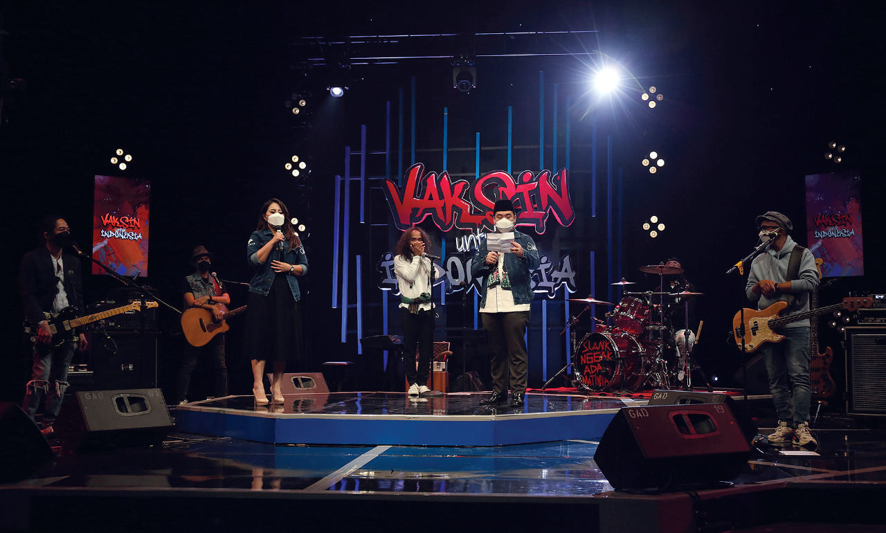 Wakil Gubernur DKI Jakarta Riza Patria (kedua kanan) membacakan puisi didampingi host Yohana dengan iringan grup band Slank.