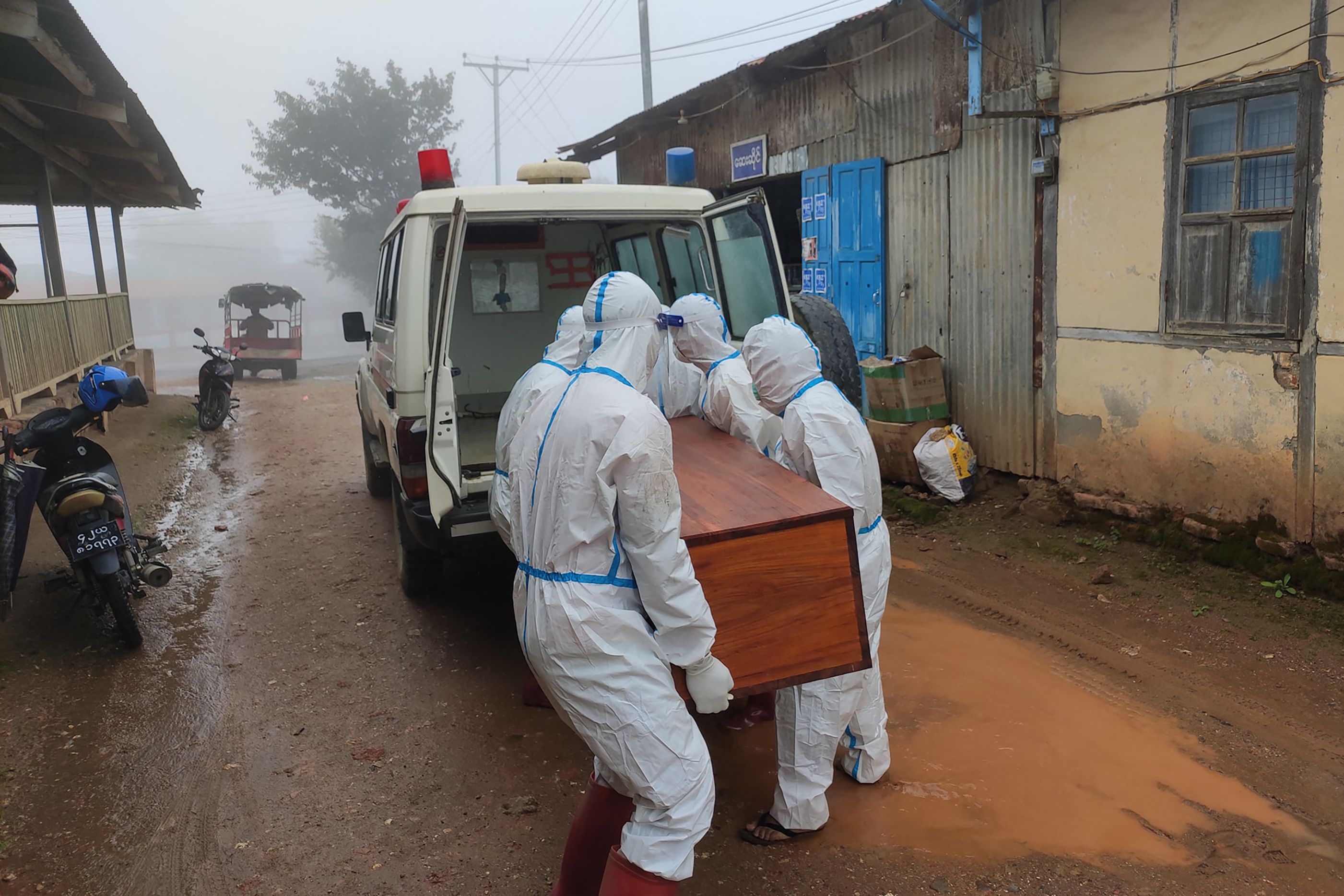 Petugas dengan APD lengkap membawa peti jenazah pasien covid-19 di wilayah Myanmar.