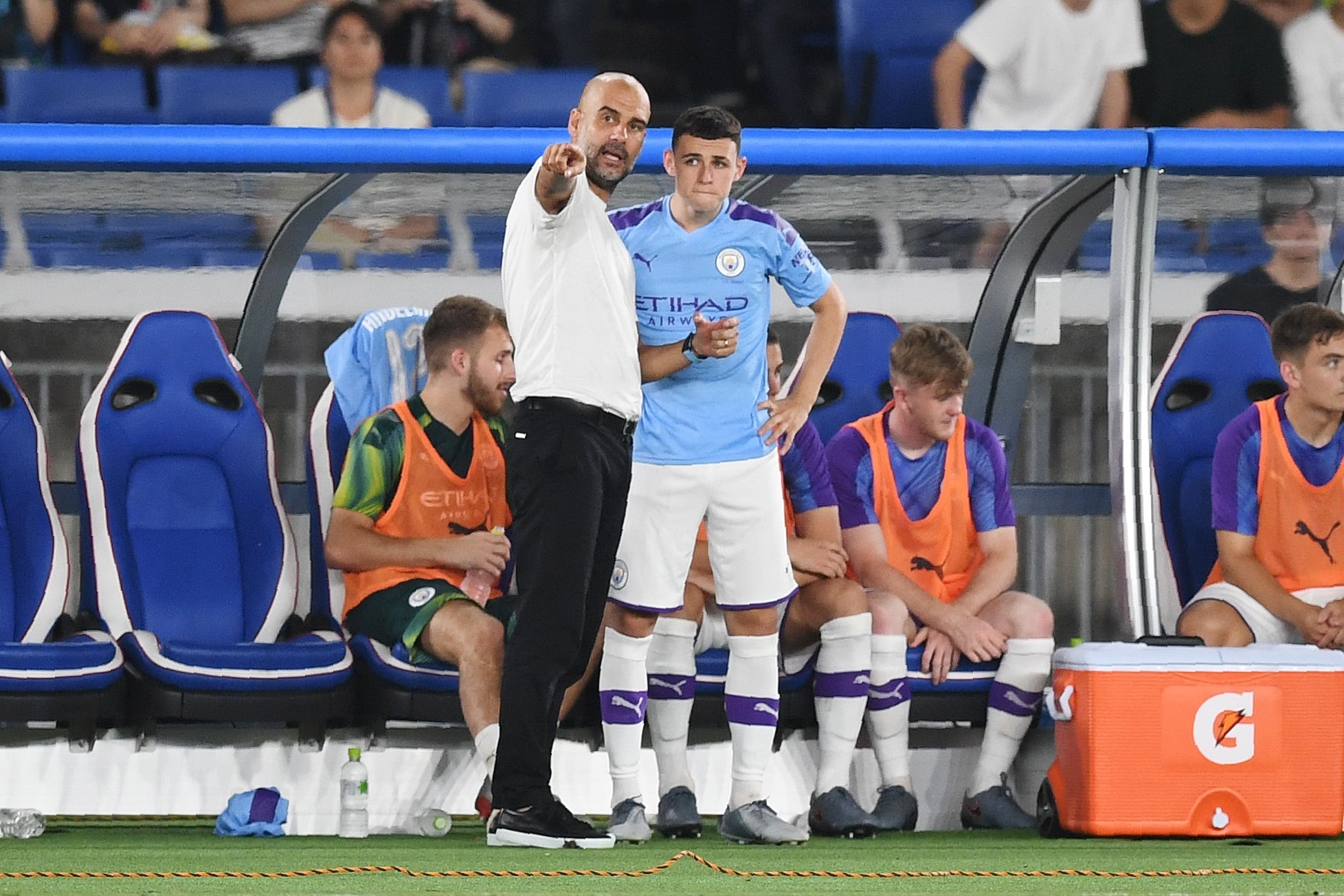 Pep Guardiola (kiri) memberikan instruksi kepada Phil Foden