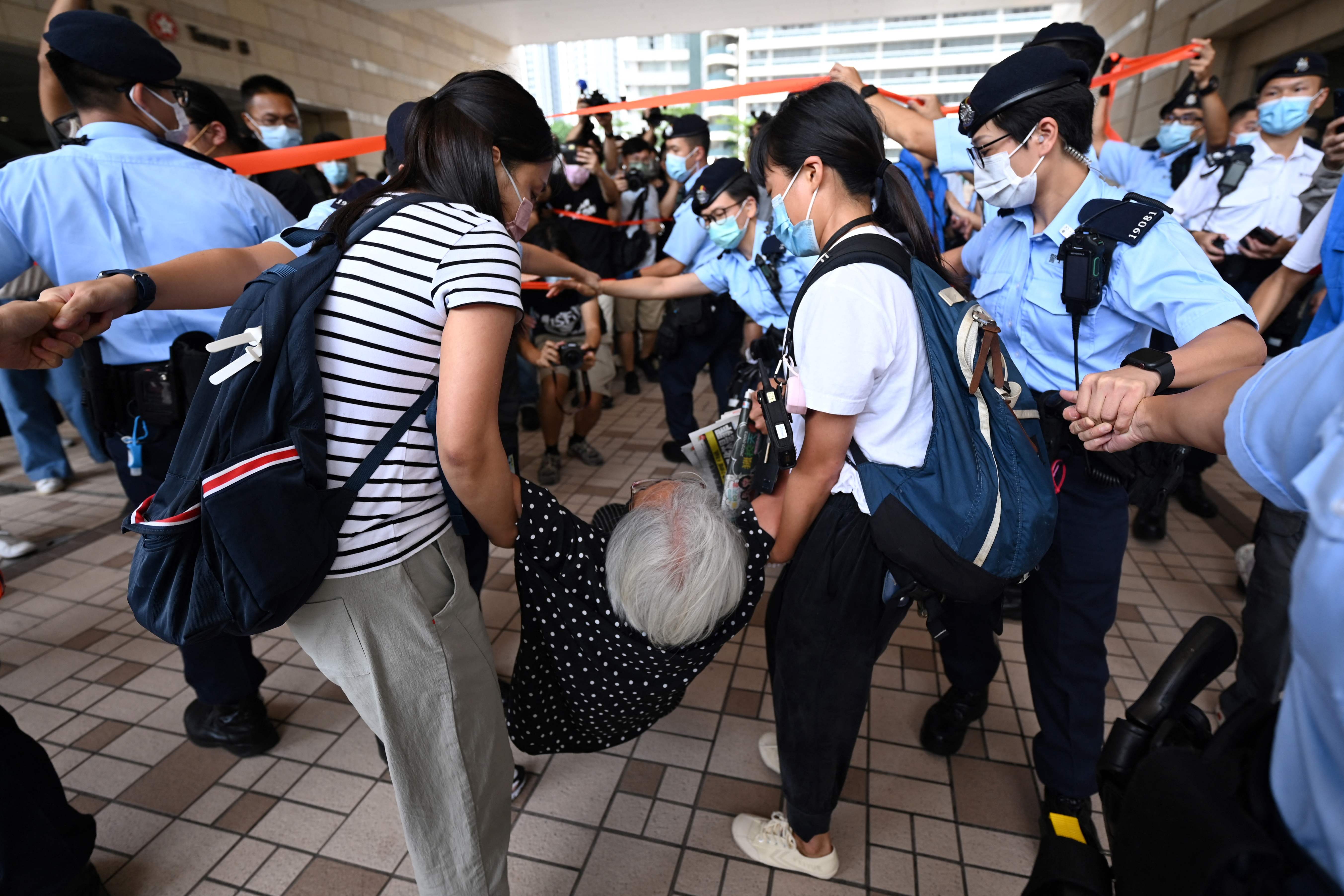 Aktivis prodemokrasi Alexandra Wong (tengah) dikeluarkan paksa aparat Hong Kong tak boleh menghadiri persidangan eksekutif Apple Daily.