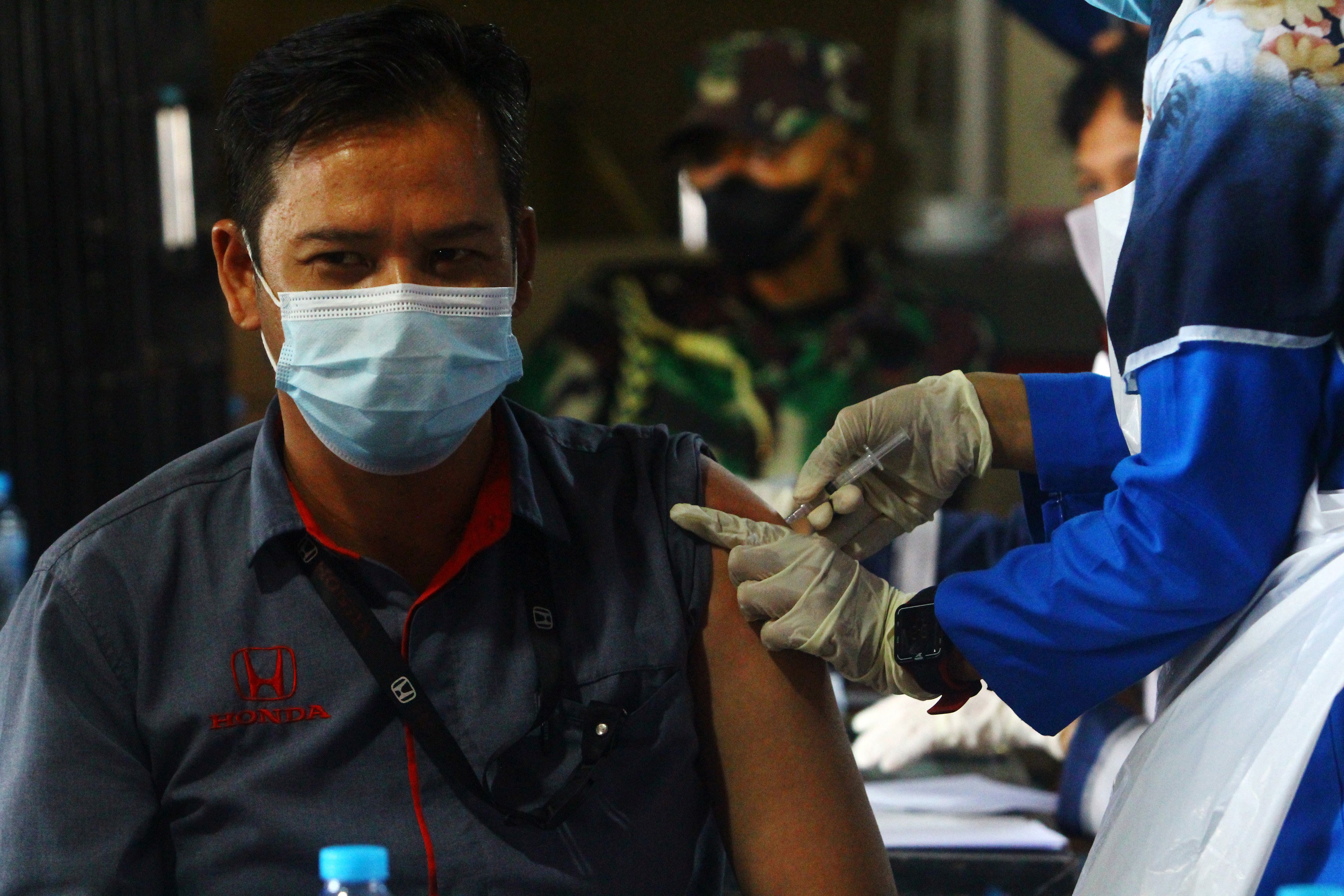 Tenaga kesehatan menyuntikkan vaksin covid-19 AstraZeneca kepada karyawan penjualan kendaraan, di Pontianak, Kalimantan Barat.