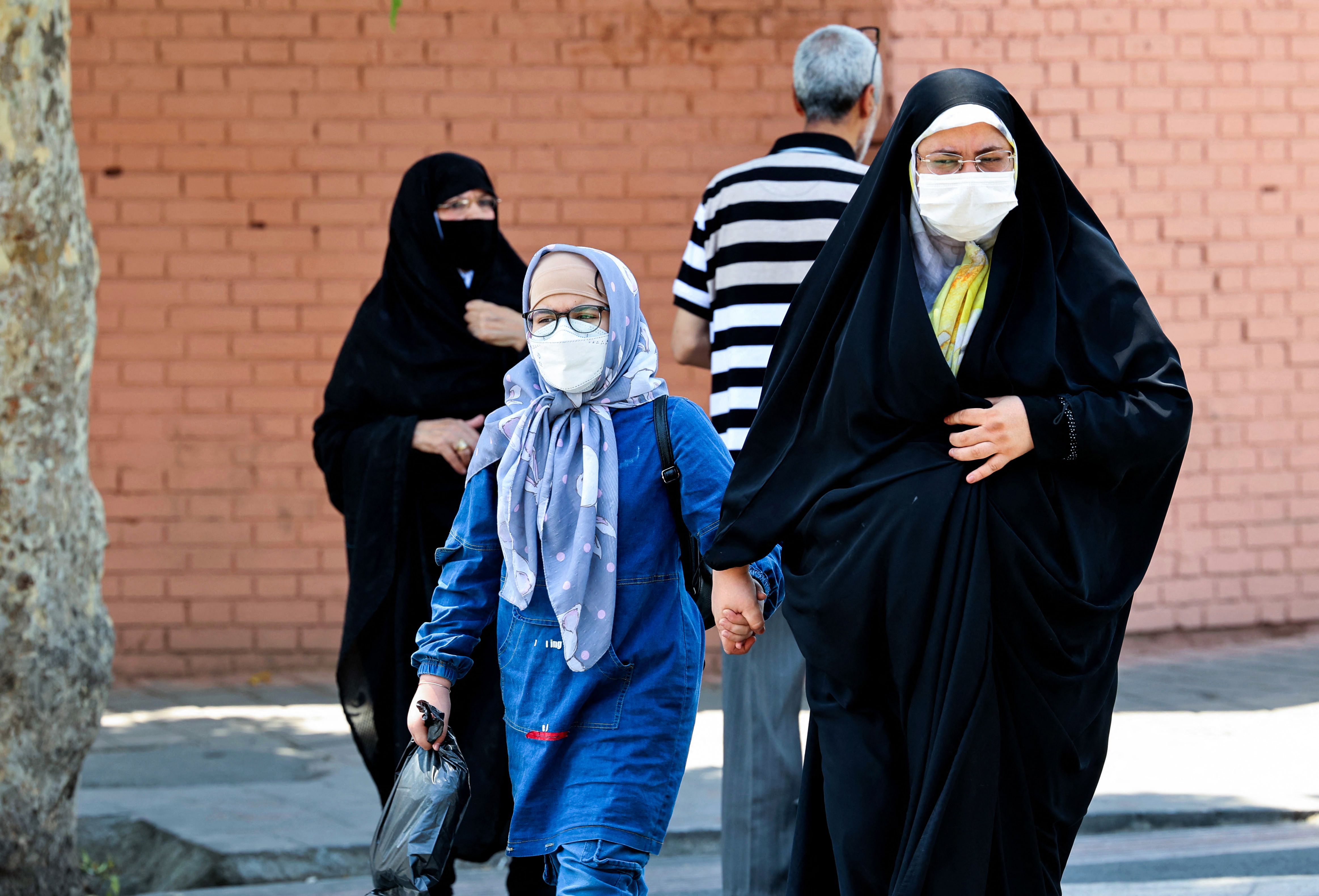 Warga Iran menggunakan masker di Lapangan Khorasan, Kota Teheran, Iran. 