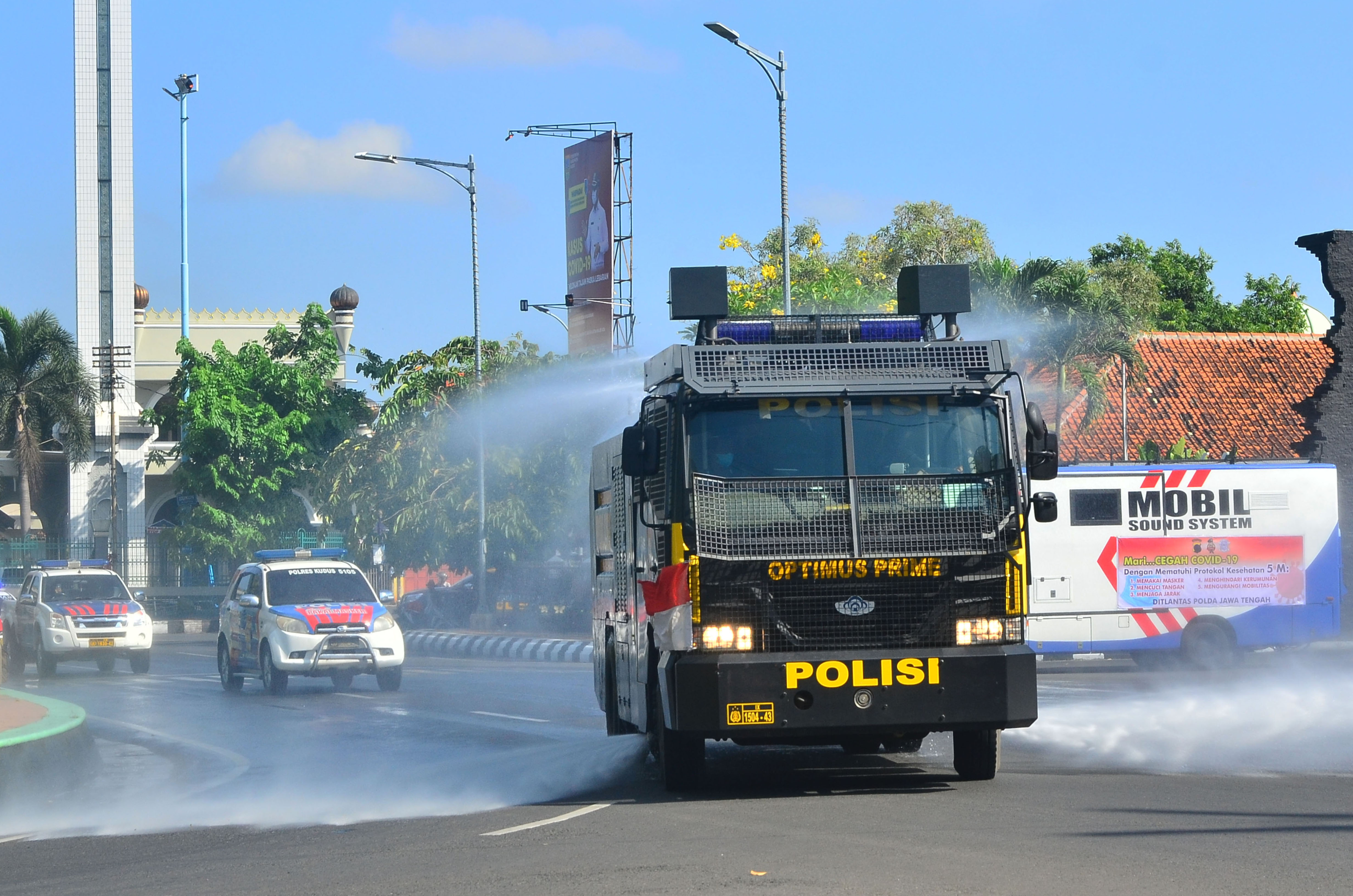 Kendaraan taktis kepolisian menyemprotkan disinfektan di jalanan utama Kabupaten Kudus, Jawa Tengah