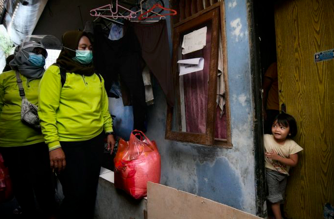 Petugas membagikan bantuan pangan kepada warga yang melakukan isolasi mandiri di Cilangkap, Jakarta