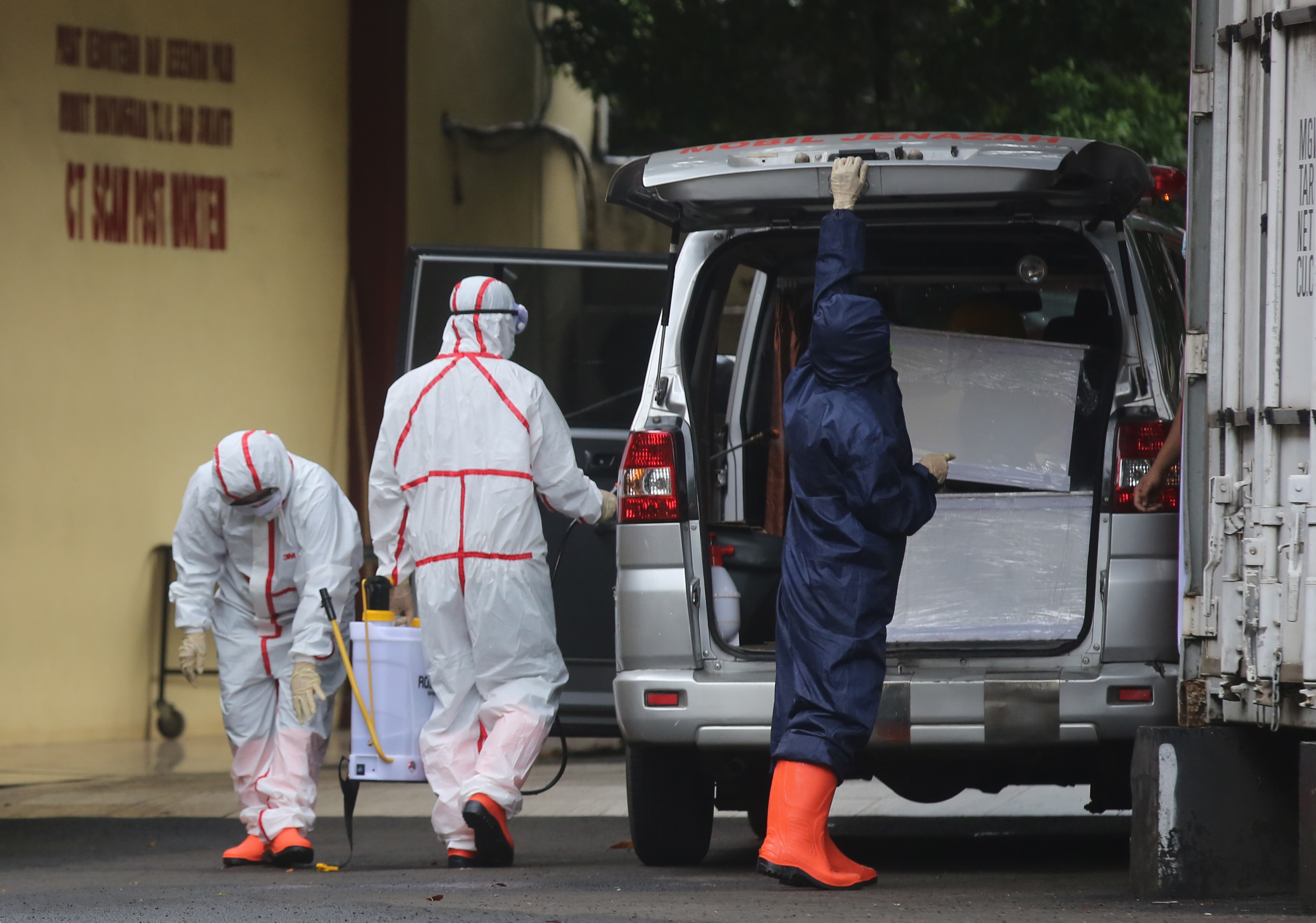 Petugas pemulasaraan jenazah bersiap membawa jenazah terkonfirmasi positif Covid-19 ke pemakaman di RS Polri, Kramat Jati, Jakarta