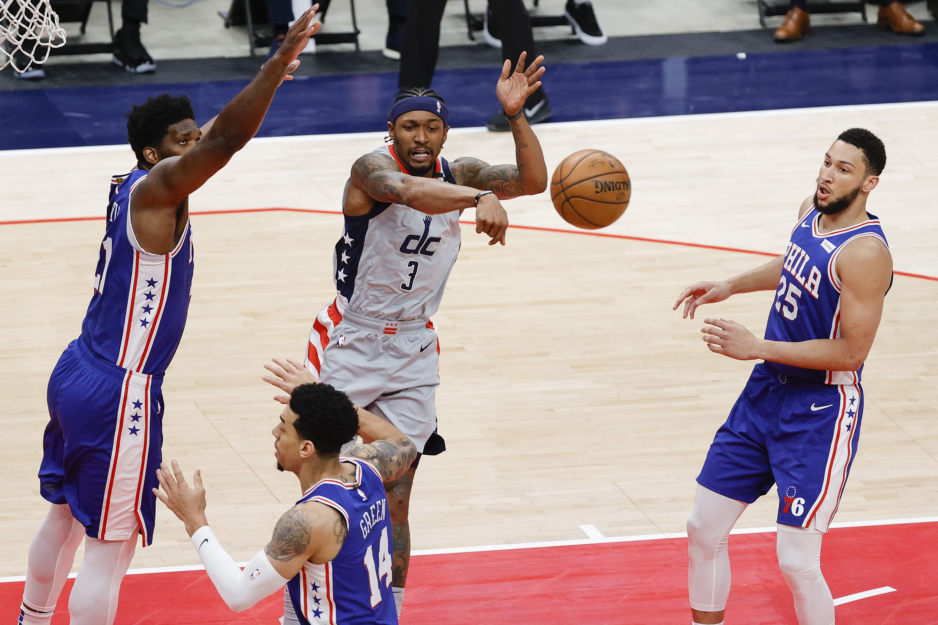 Pemain Washington Wizards Bradley Beal mengoper bola di antara kepungan pemain Philadelphia 76ers di laga putaran pertama playoff NBA.