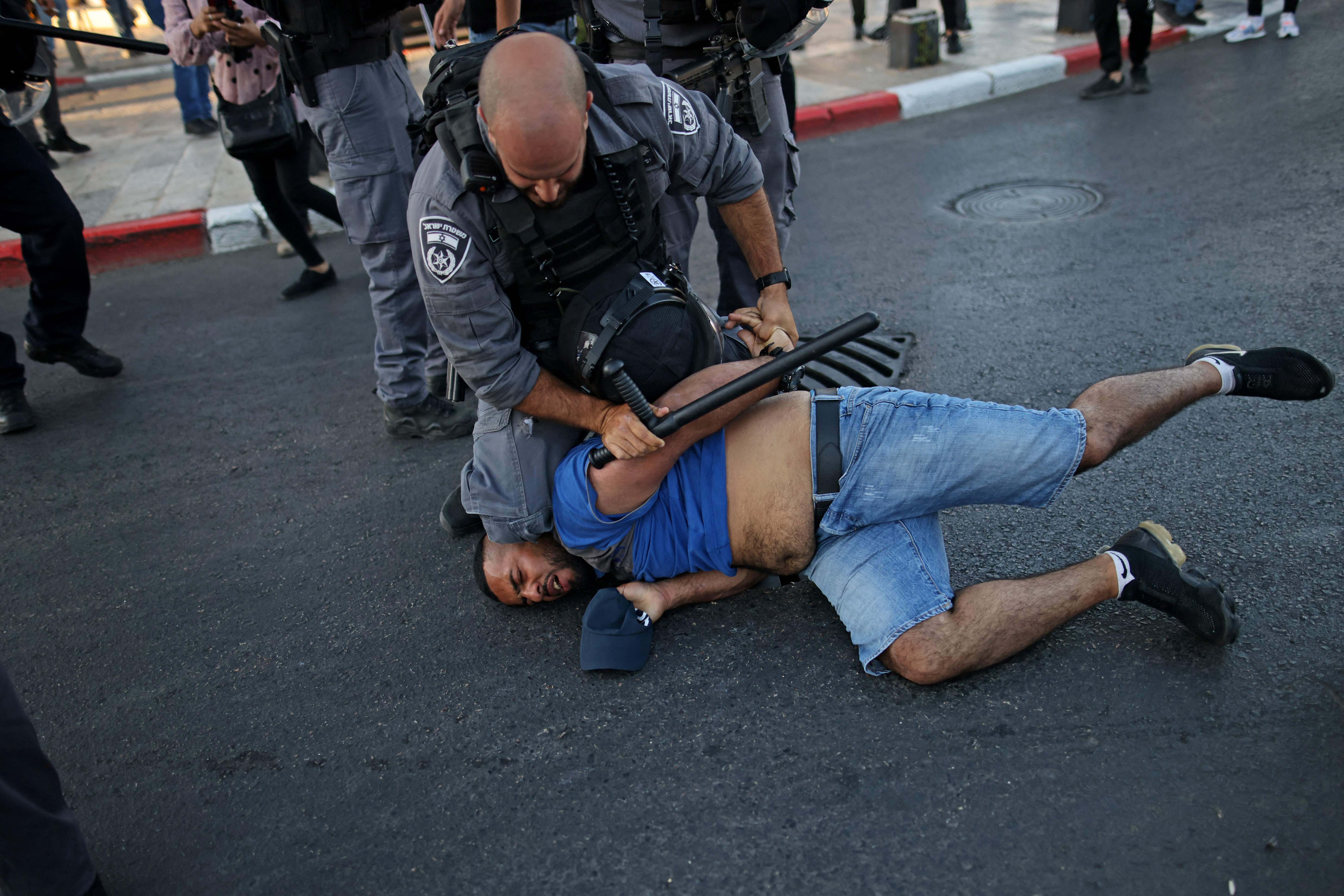 Pasukan keamanan Israel menahan seorang warga Palestina di luar gerbang Damaskus di Kota Tua Jerusalem, Kamis (17/6), selama protes.