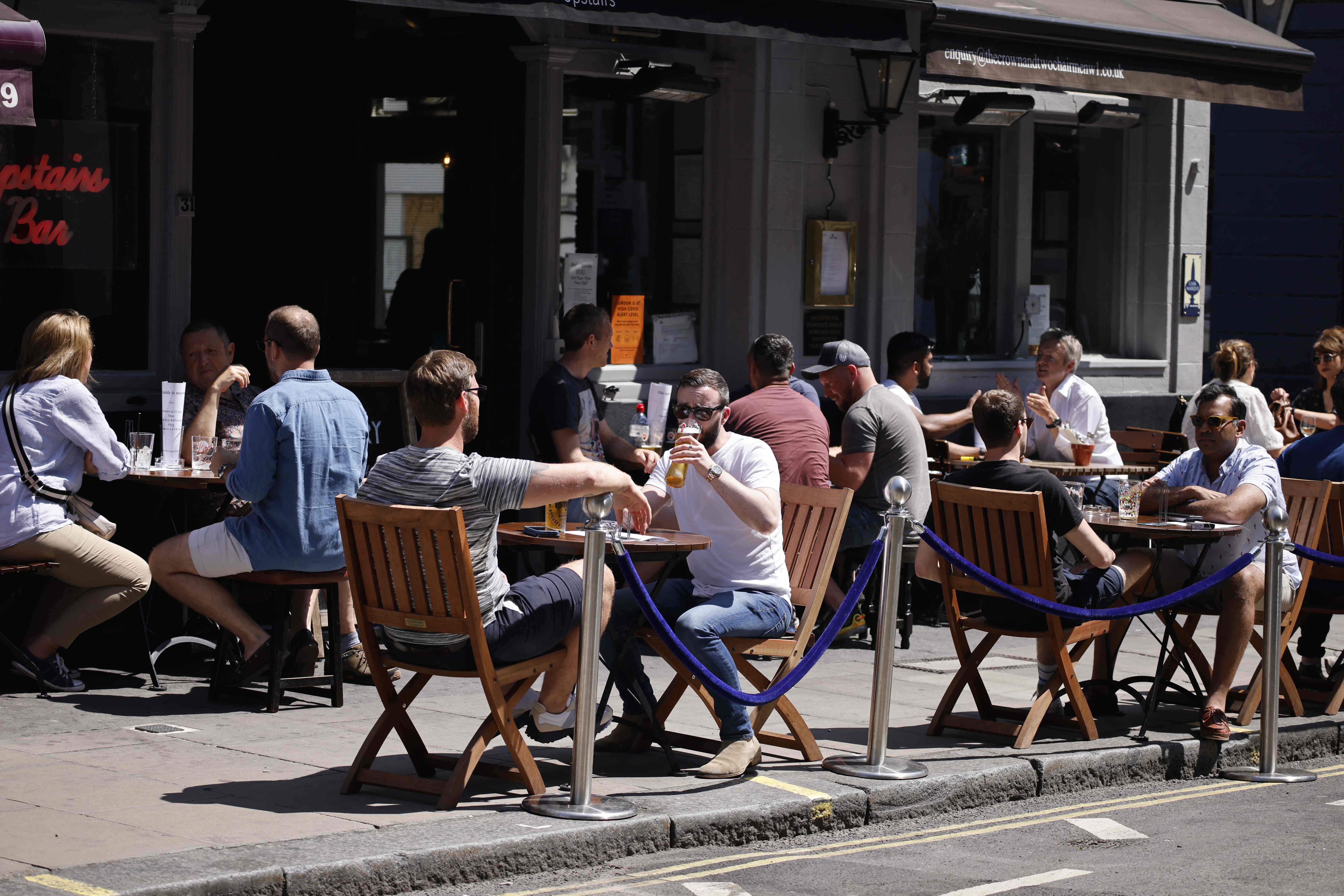 Orang-orang menikmati minuman dan makan siang di luar bar, pusat kota London, Inggris, pada 3 Juni 2021.