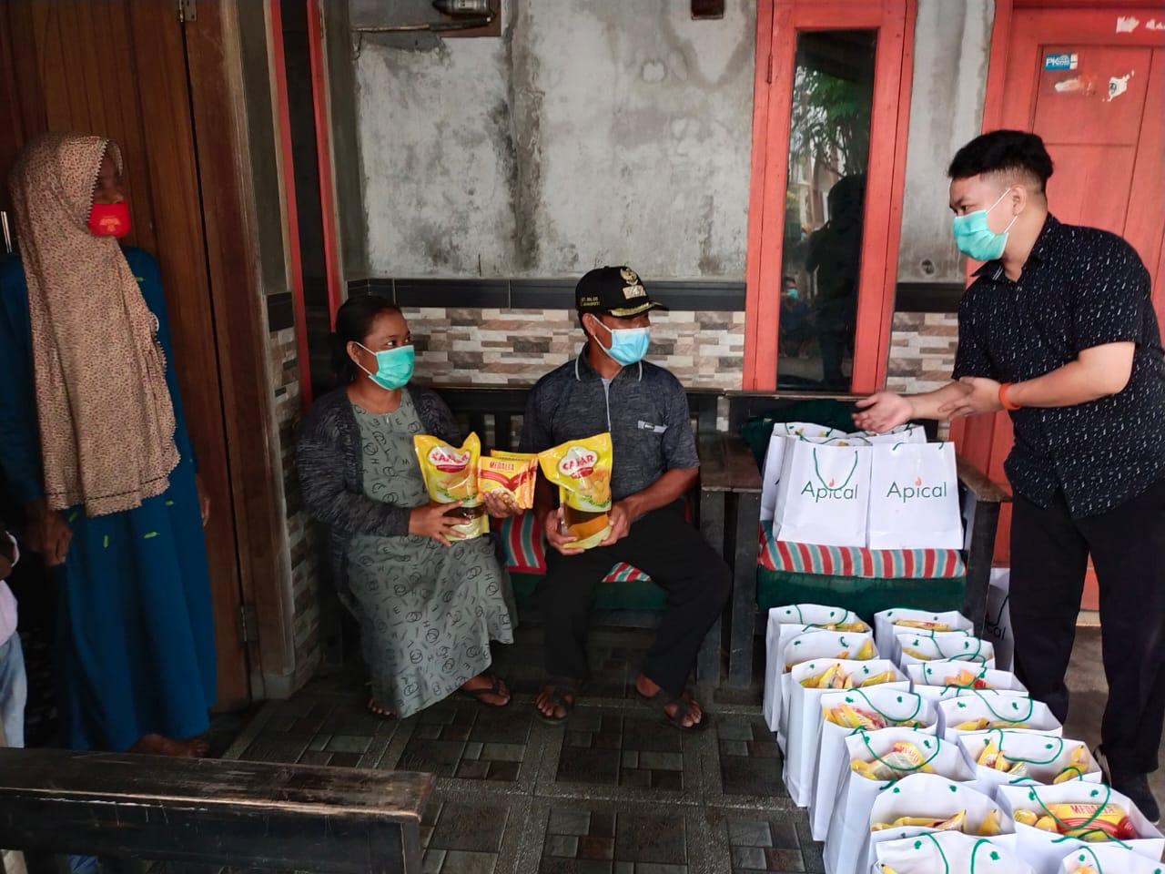 Petugas membagikan sembako kepada warga.