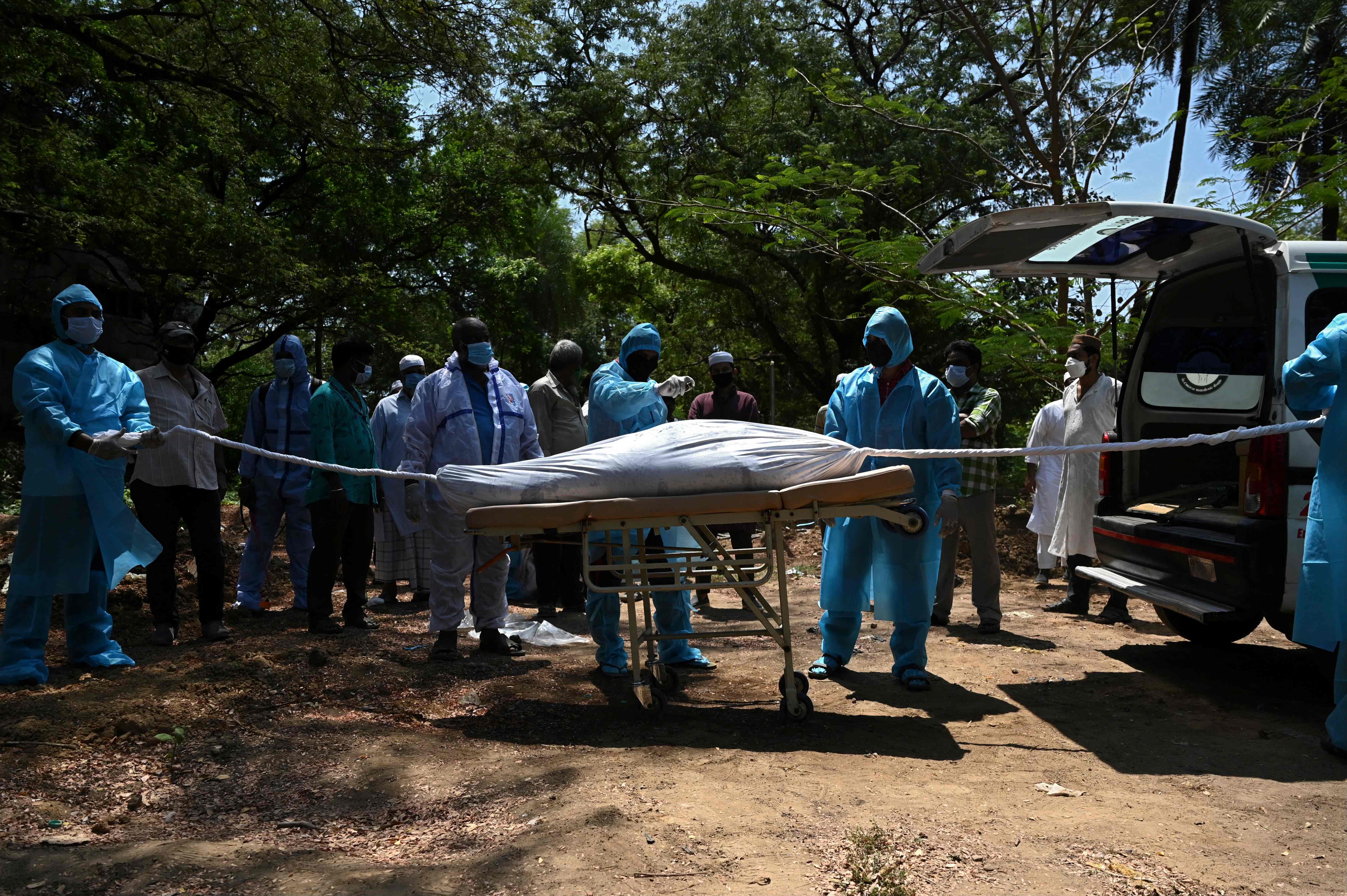 Petugas di Chennai, India, mengenakan APD untuk proses pemakaman jenazah pasien covid-19.