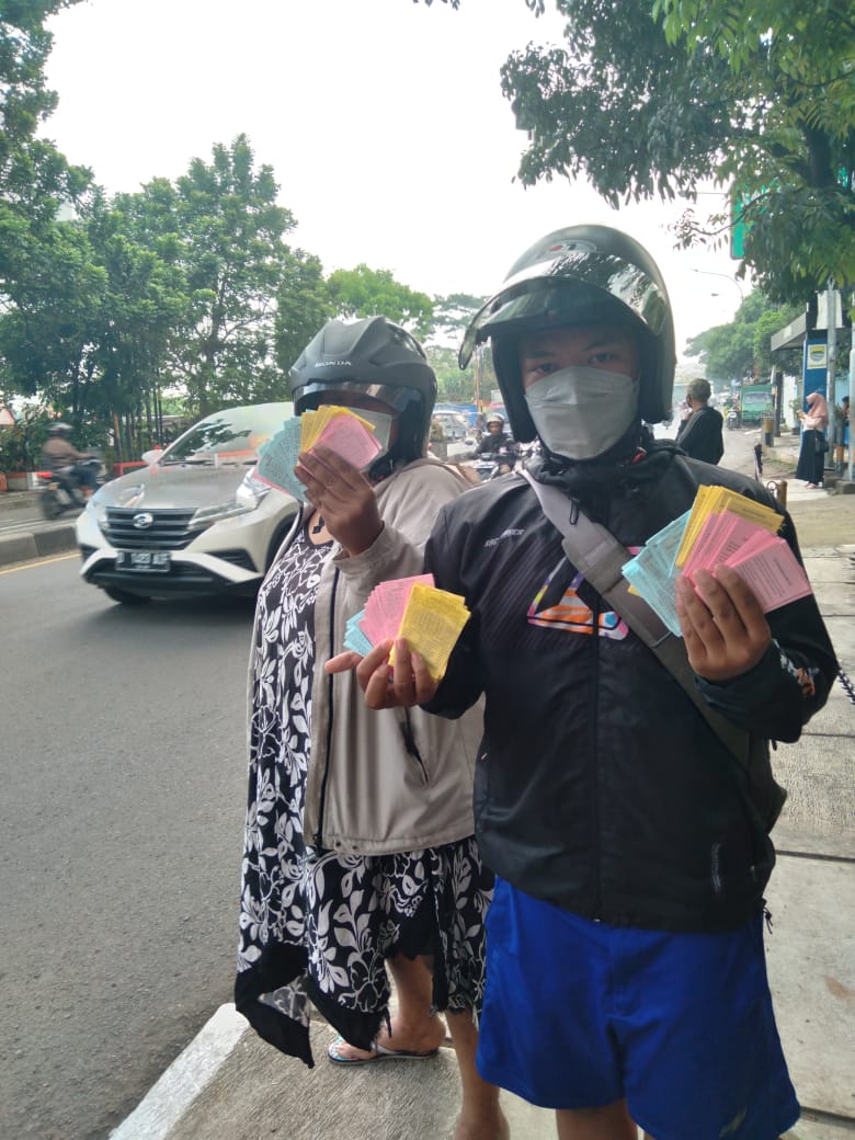 Seorang warga menunjukkan kupon judi togel yang dipungut di jalan depan Gedung Sate