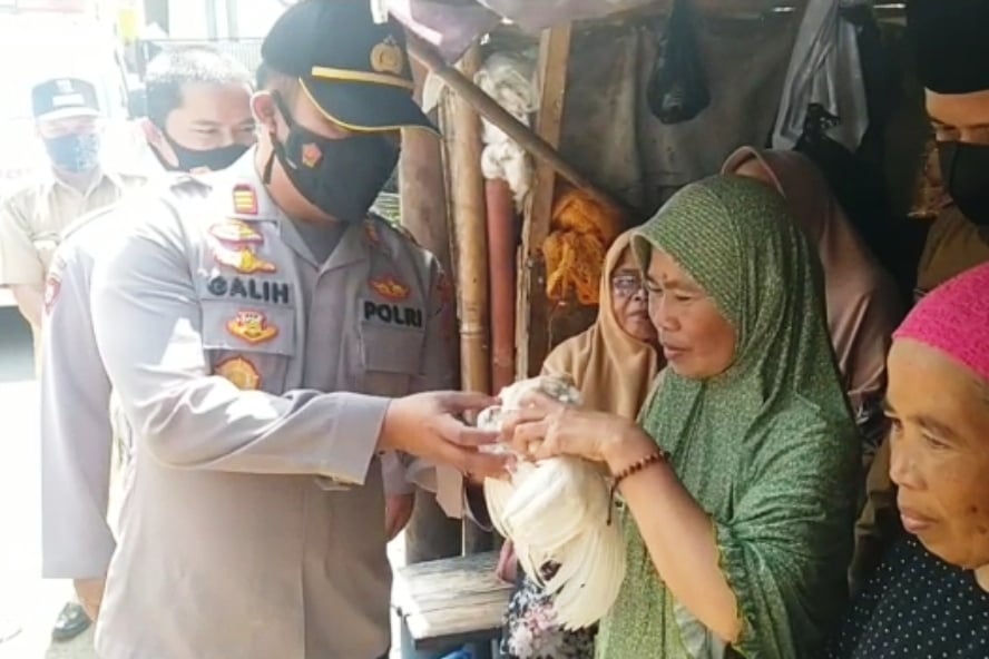 Kapolsek Pacet Ajun Komisaris Galih Apria menyerahkan seekor ayam hidup kepada seorang lansia yang rela divaksin.