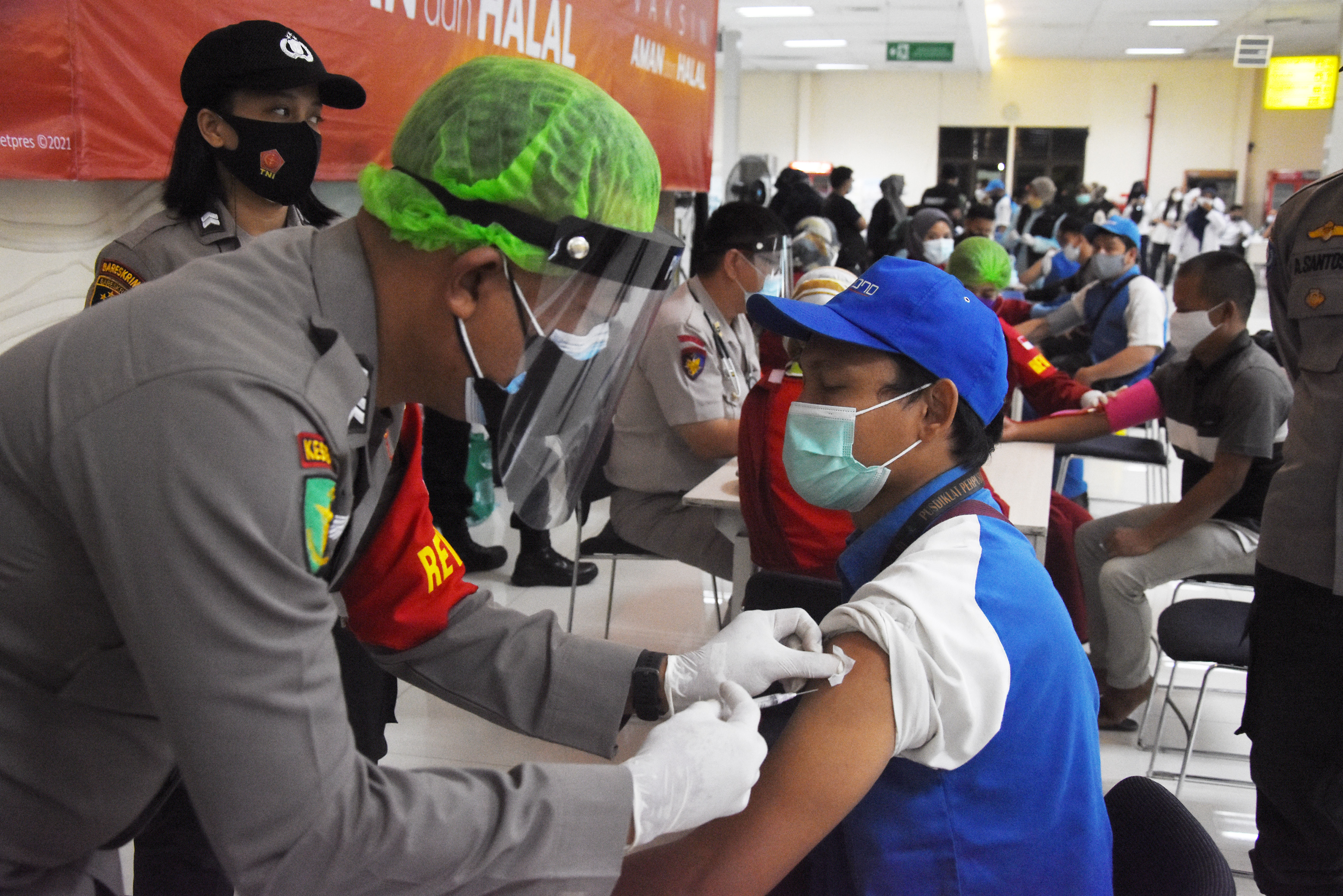 VAKSINASI: Seorang petugas memberikan vaksin covid-19 kepada seorang pekerja di Terminal Penumpang Pelabuhan Tanjung Priok, Jakarta.