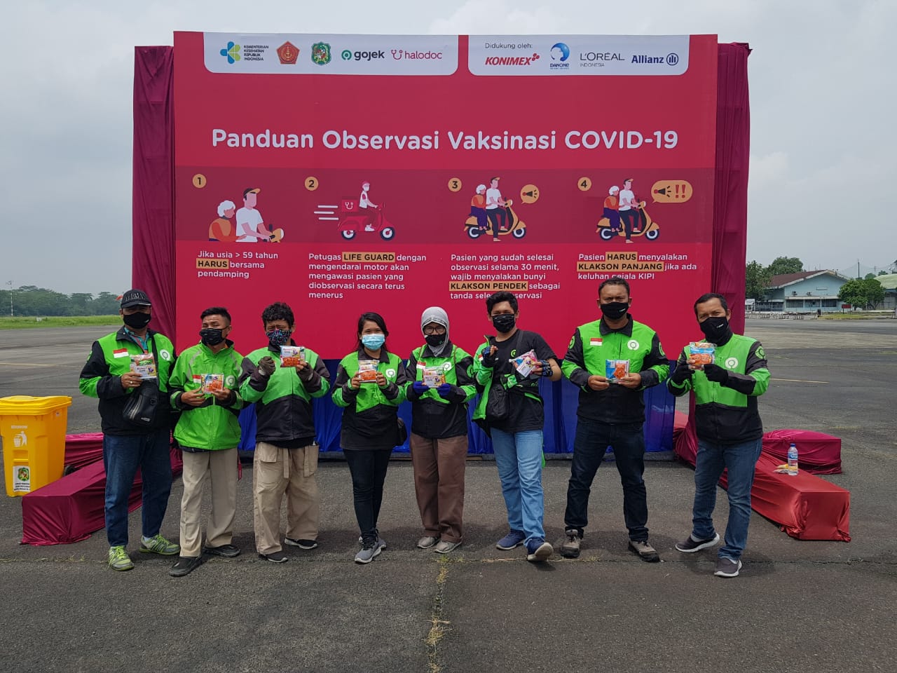 Sejumlah pengemudi ojek online berfoto bersama seusai mendapatkan vaksinasi dari Konimex dan Halodoc