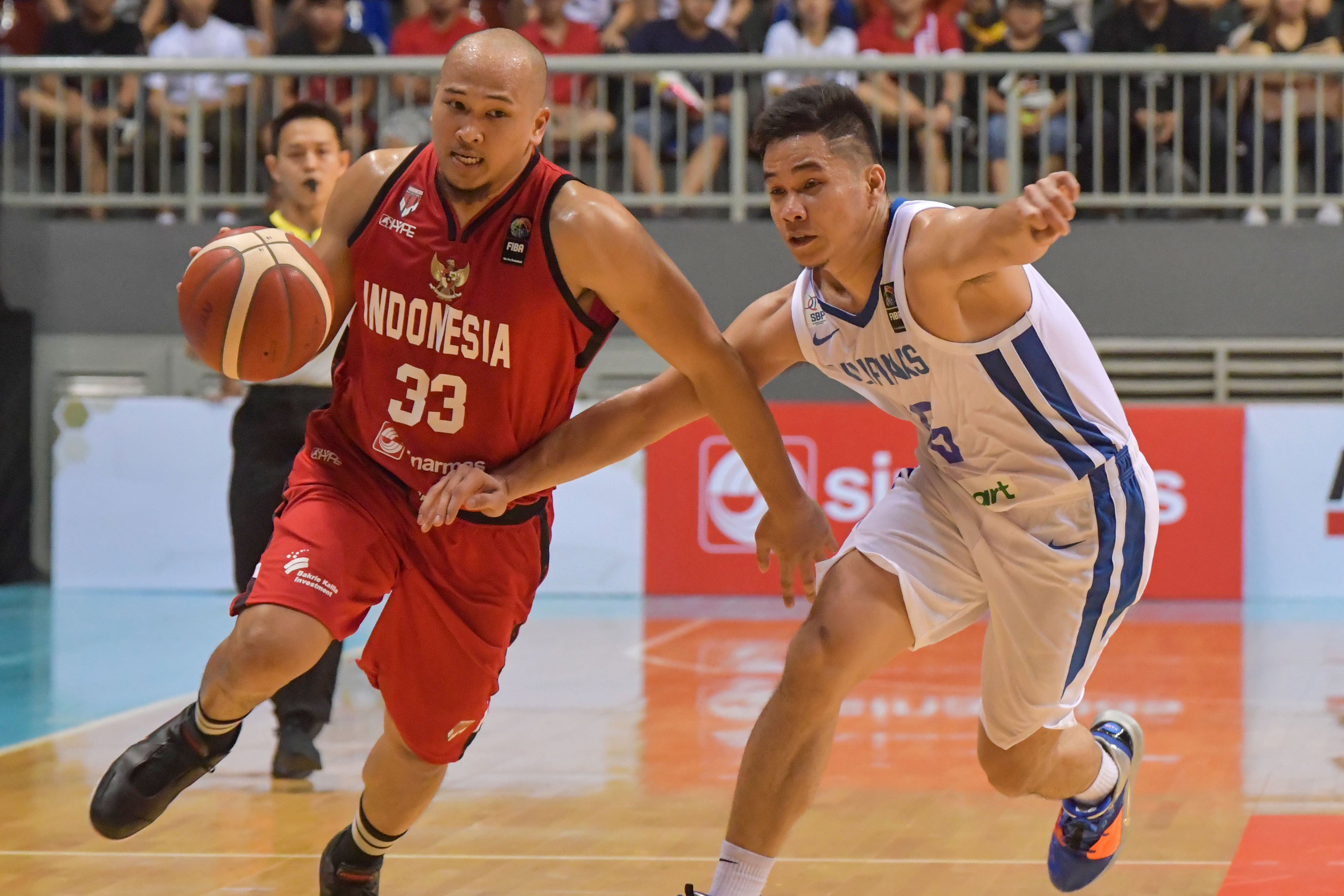 Pebasket Indonesia saat berusaha melewati hadangan pebasket Filipina dalam kualifikasi FIBA Asia Cup.