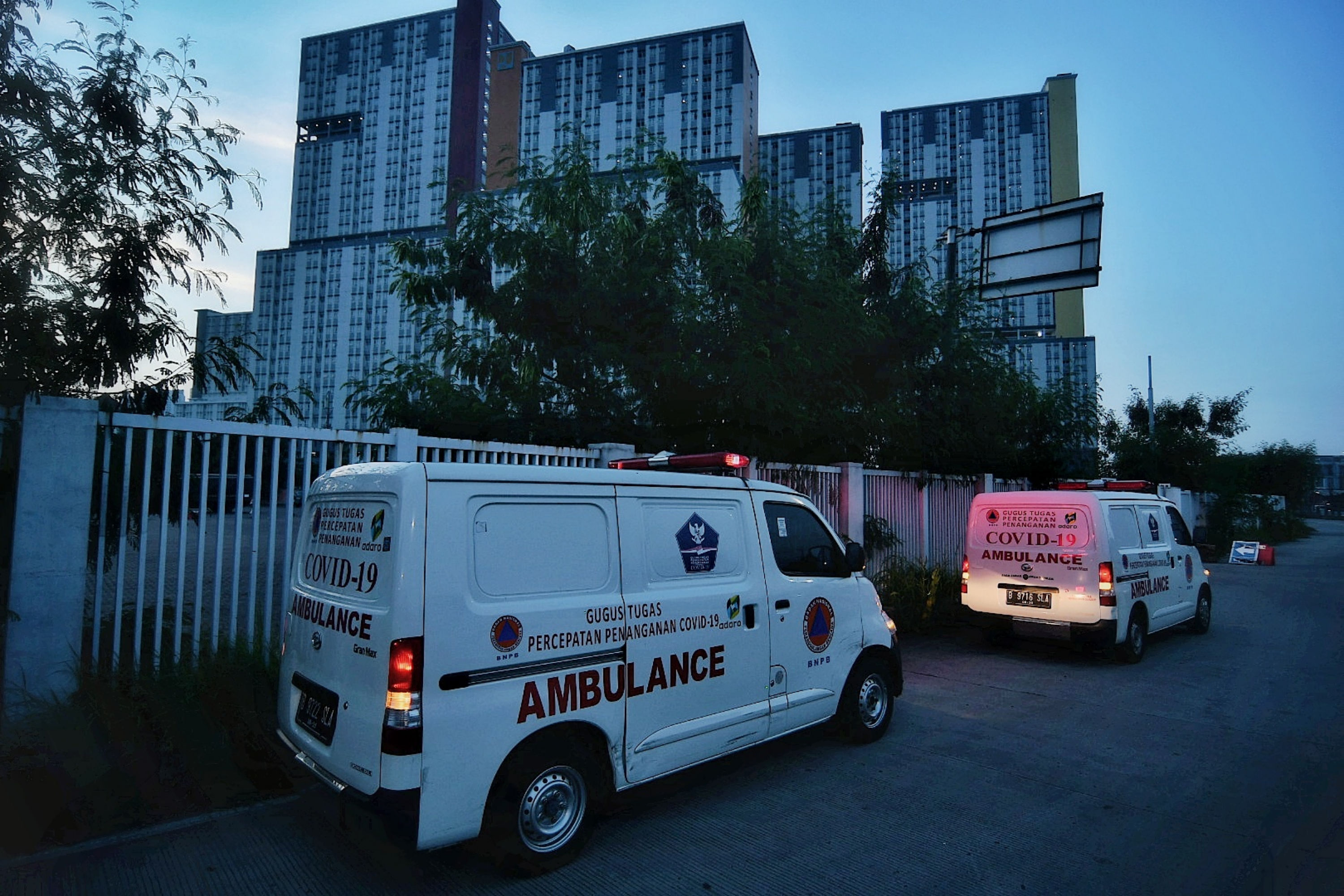 Kendaraan ambulance membawa pasien positif Covid-19 memasuki RSD Wisma Atlet Kemayoran, Minggu (13/6).