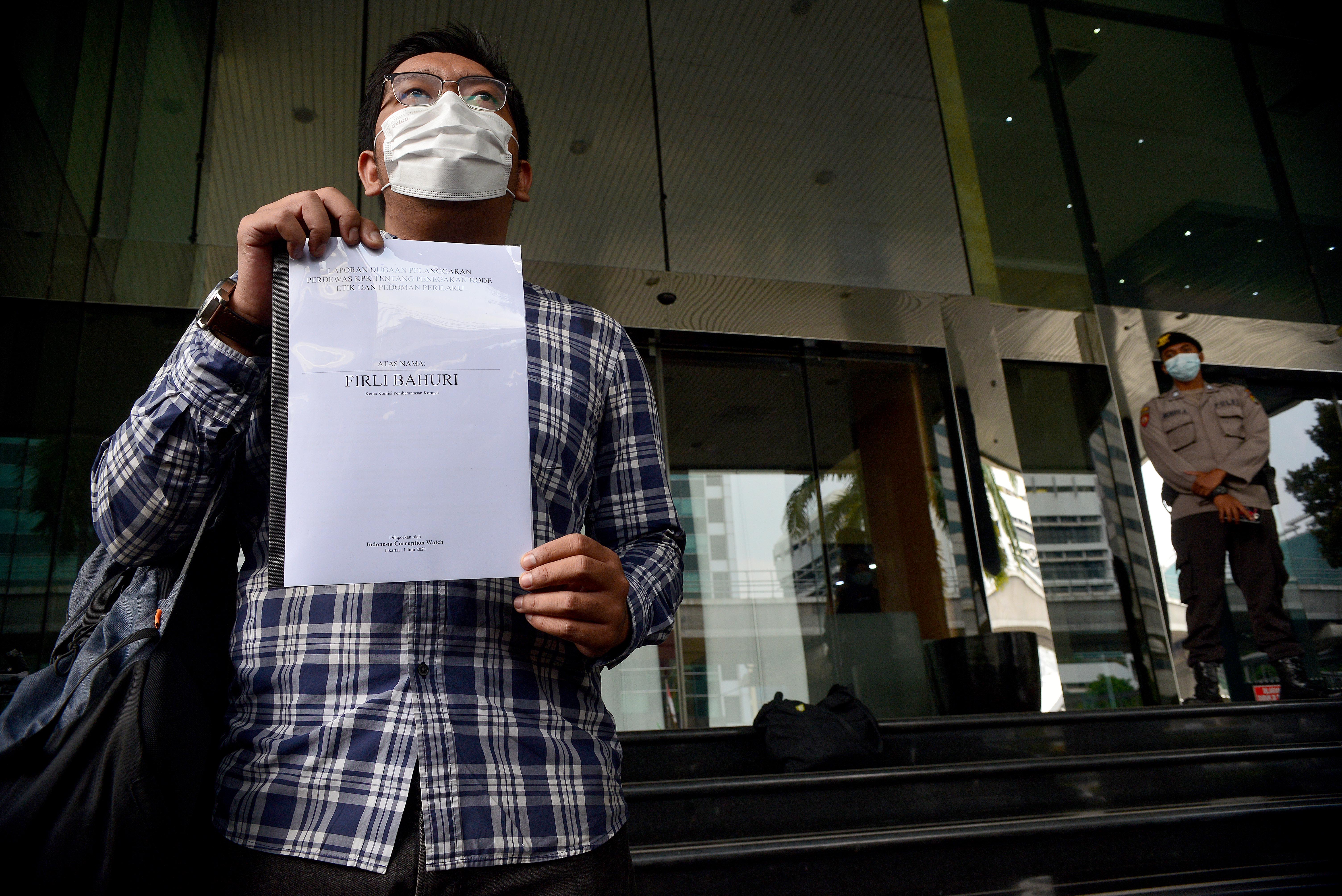 Peneliti ICW Kurnia Ramadhana menunjukkan laporan pihaknya atas Firli Bahuri ke Dewas KPK