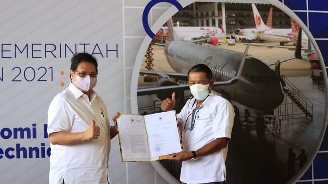 Penyerahan PP 67/ 2021 oleh (kiri) Menko Bidang Perekonomian RI, Airlangga Hartarto kepada Presiden Direktur Lion Air Group, Edward Sirait.