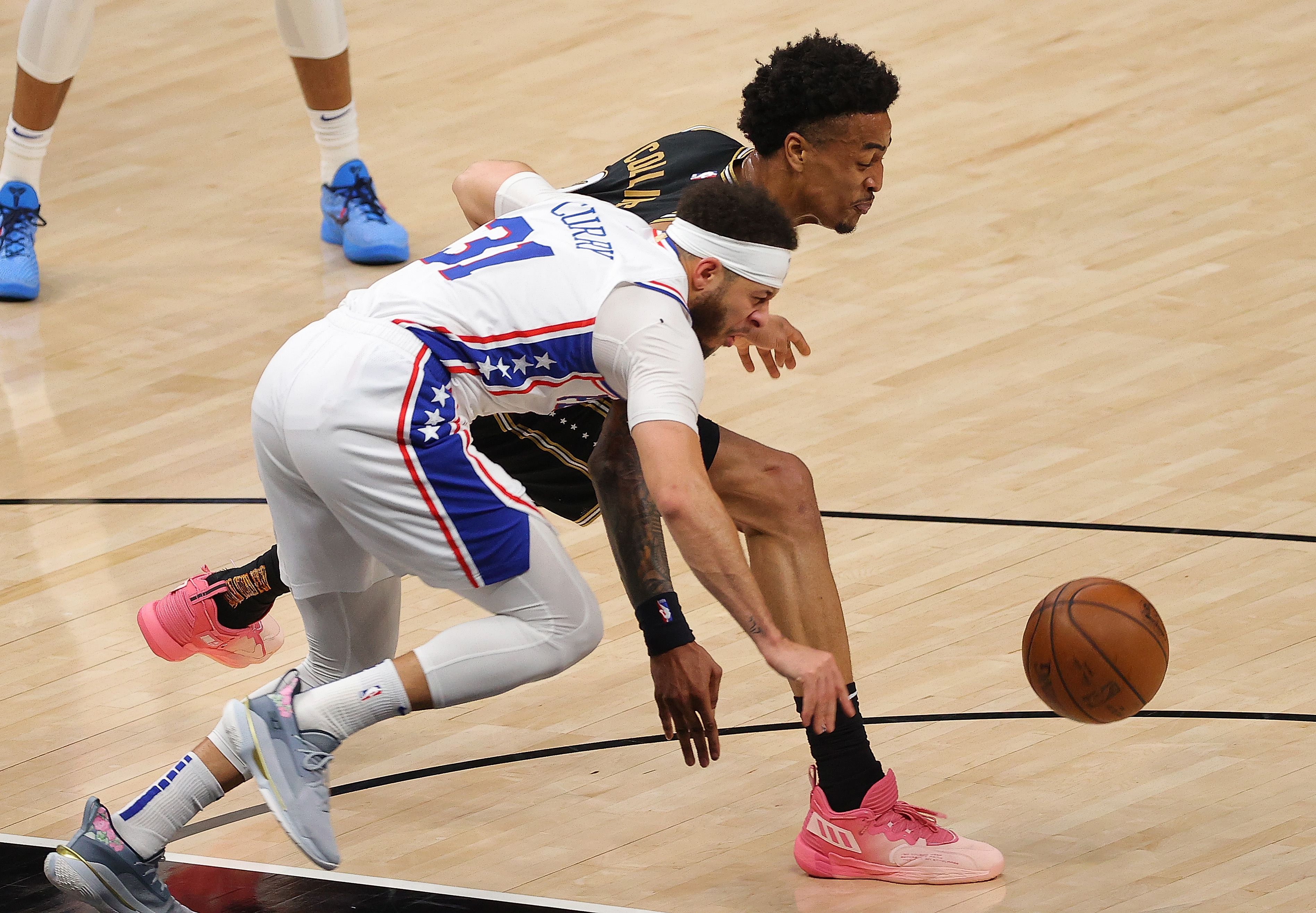 Pemain Philadelphia 76ers Seth Curry (kaus putih) berebut bola dengan John Collins dari Atlanta Hawks di laga ke-6 Semifinal Wilayah Timur.
