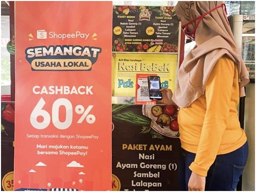 Seorang pengunjung sedang melakukan transaksi digital menggunakan ShopeePay sembari menikmati promo cashback 60%. 