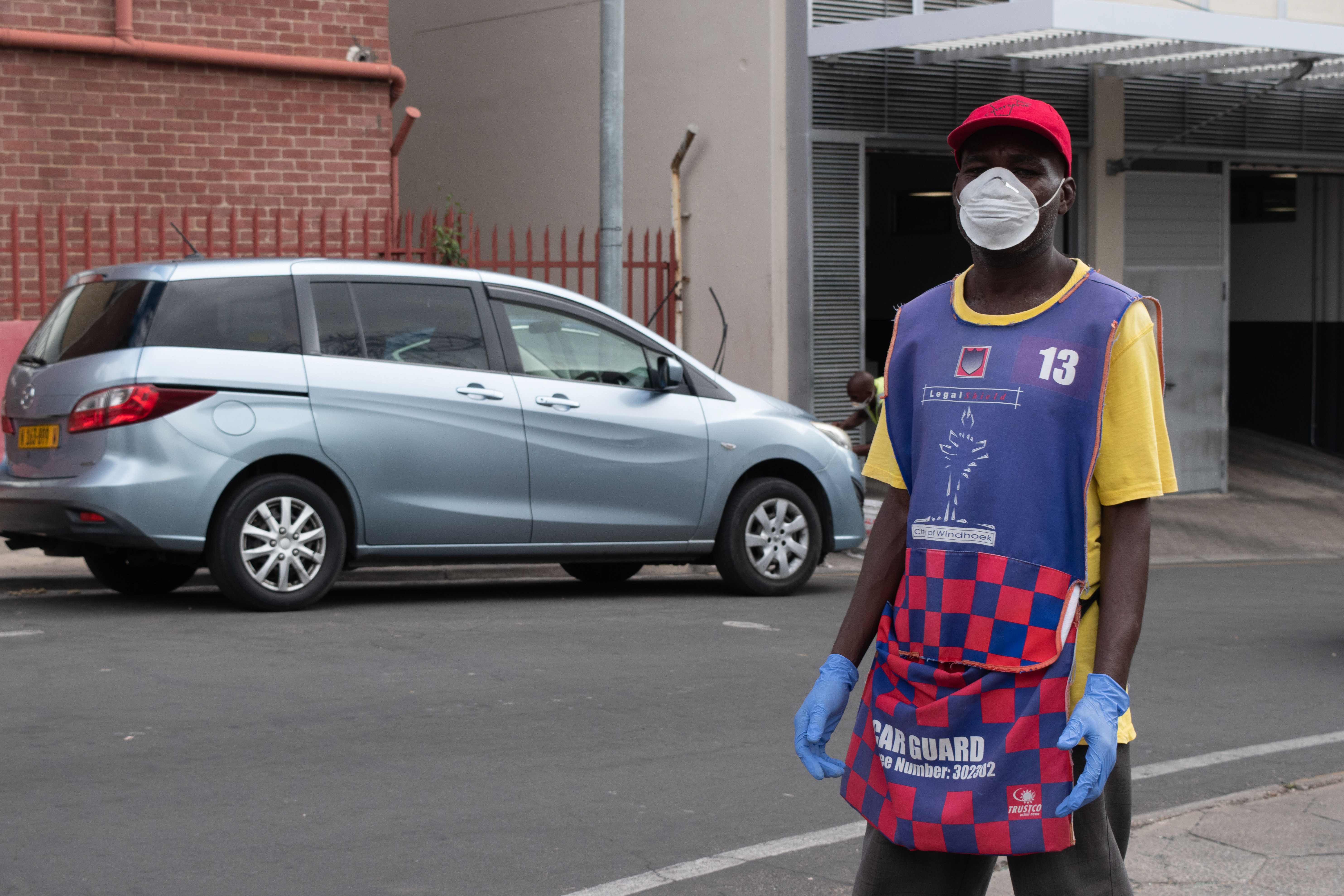 Seorang juru parkir mengenakan masker di Windhoek, Namibia.