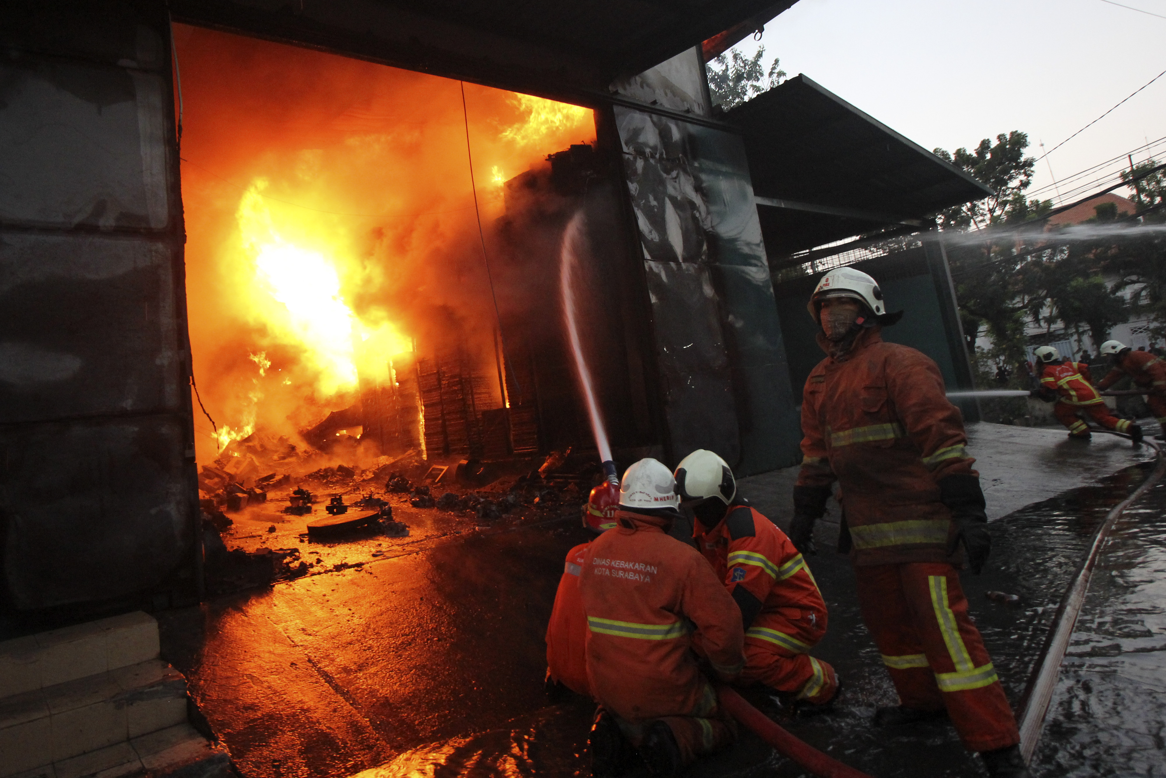Petugas pemadam kebakaran berupaya memadamkan api di salah satu rumah warga.