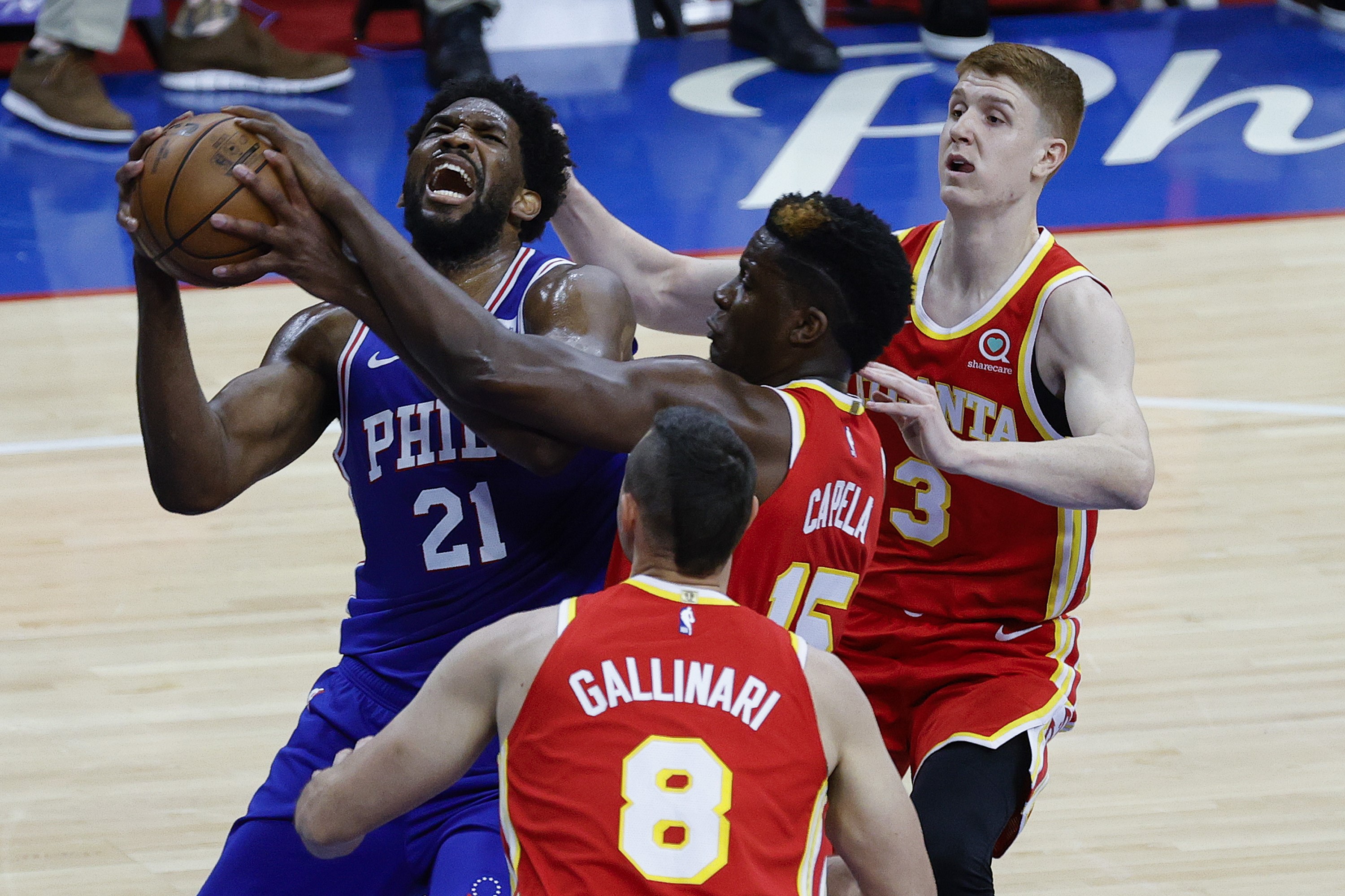 Pemain center 76ers, Joel Embiid (kiri), dikepung tiga pemain Atlanta Hawks pada laga kedua babak semifinal Wilayah Timur.