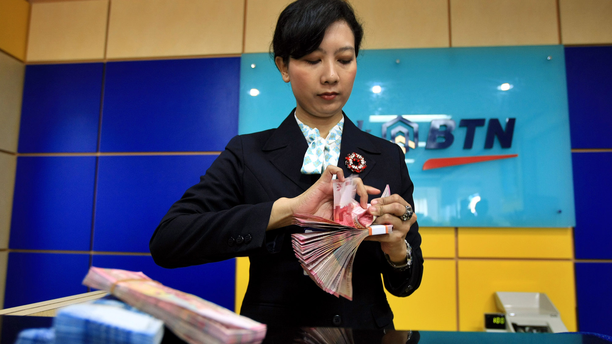 Teller menghitung uang setoran nasabah