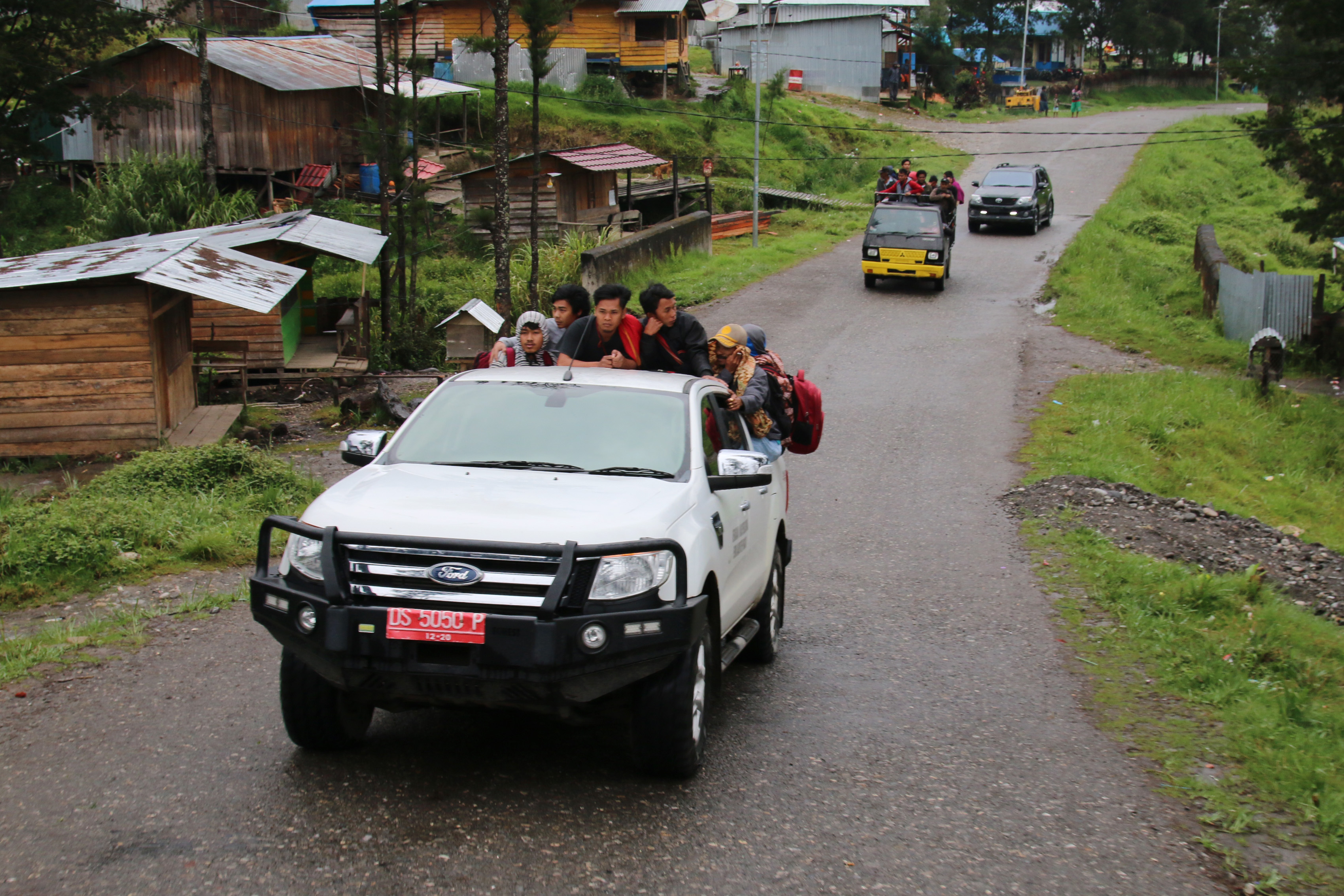 Ilustrasi warga Ilaga, Papua, menaiki mobil bak terbuka untuk mengungsi.