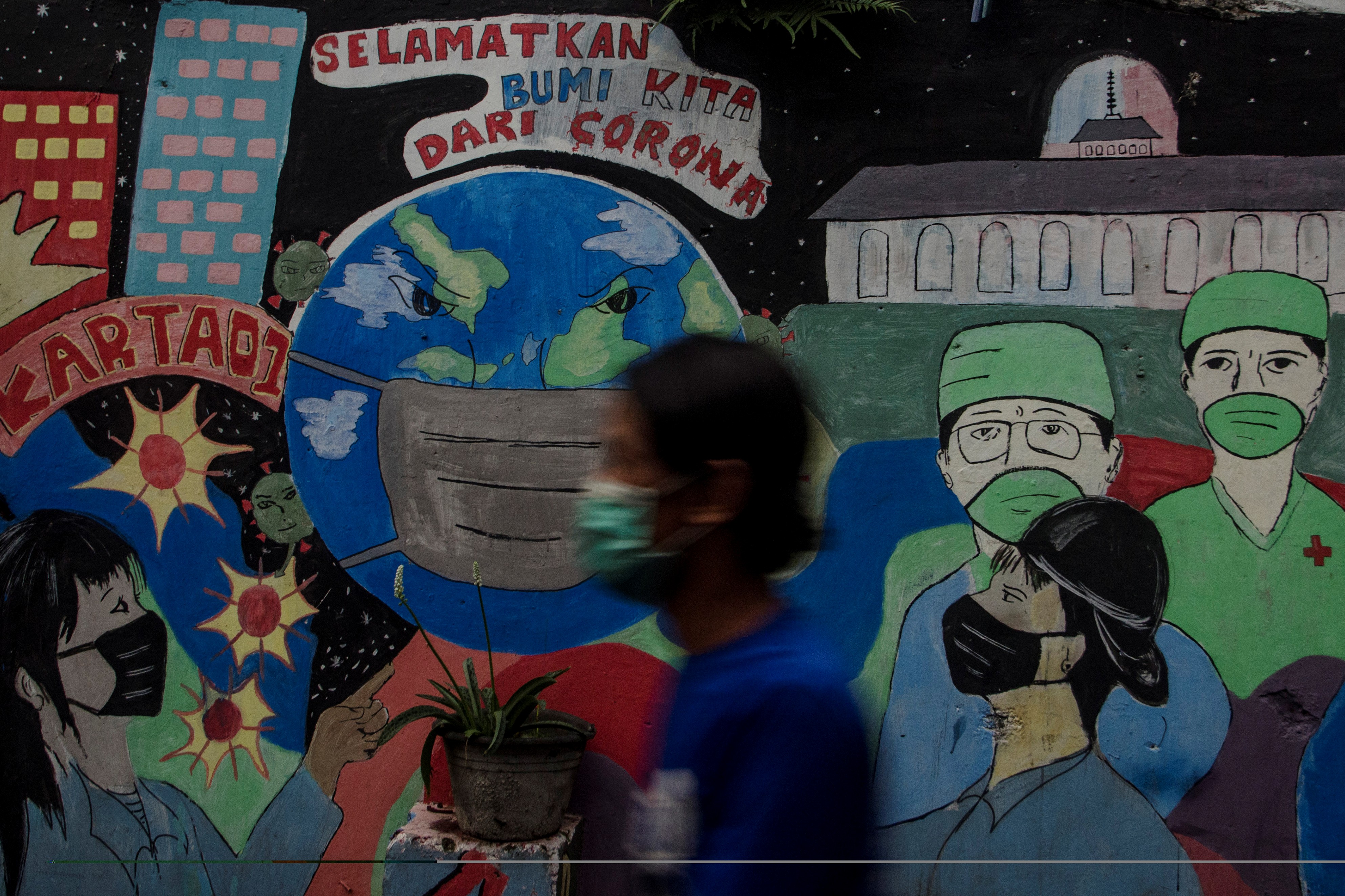 Warga melintasi mural bertema covid-19 di Bandung, Jawa Barat, beberapa waktu lalu.