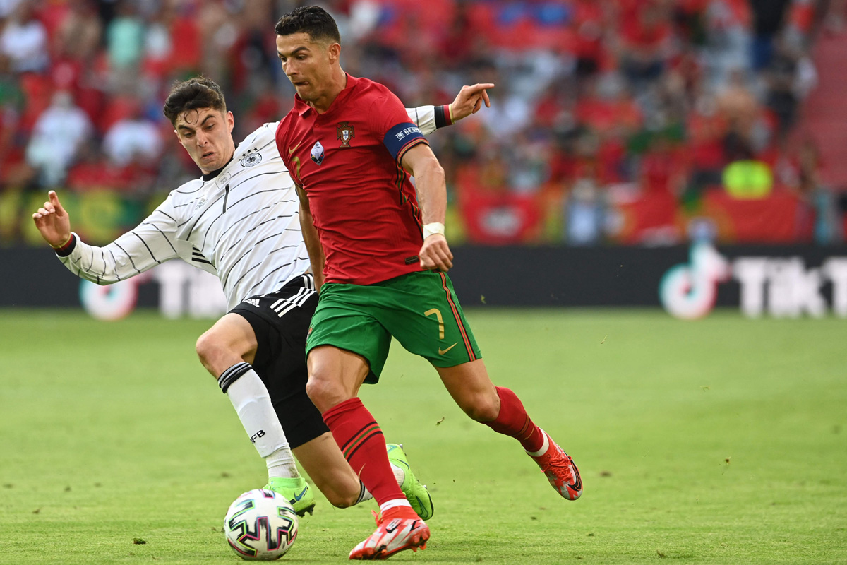 Pemain Portugal Cristiano Ronaldo (kanan) berusaha melewati hadangan pemain Jerman dalam laga penyisihan Grup F EURO 2020, Minggu (20/6).  