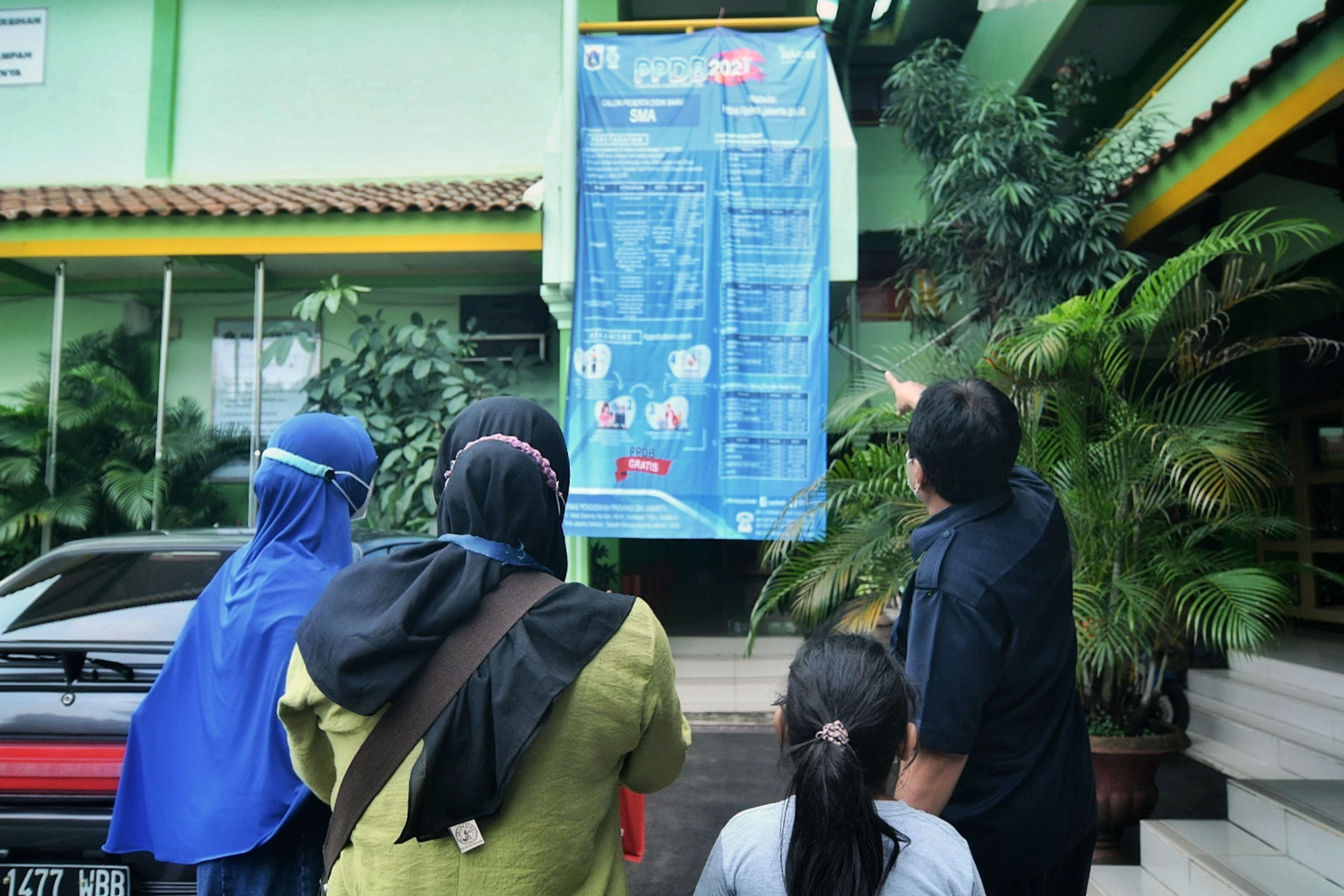 Wali murid melihat pengumuman PPDB