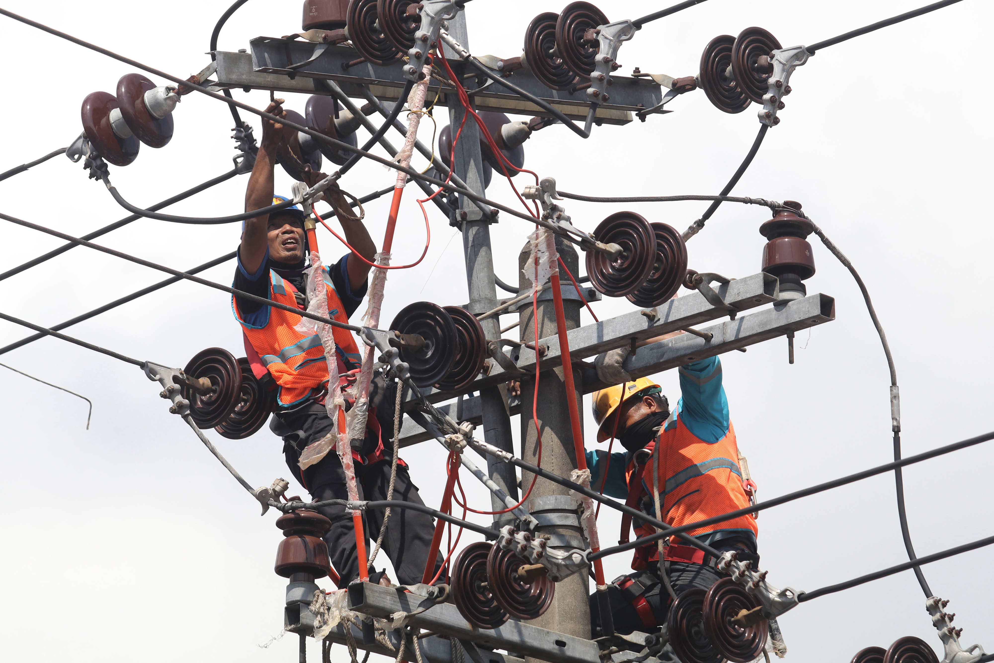 Ilustrasi petugas saat memperbaiki jaringan listrik.