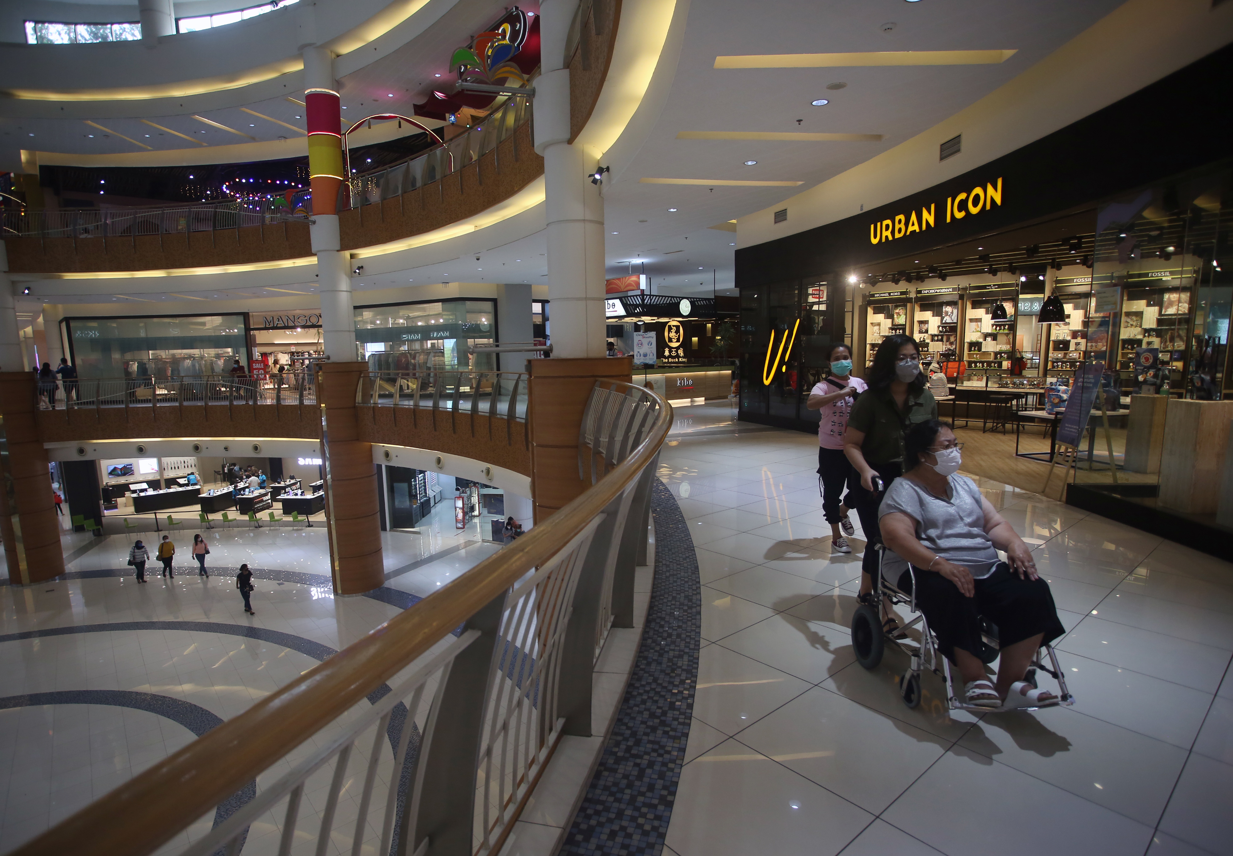 Pengunjung mal mengenakan masker