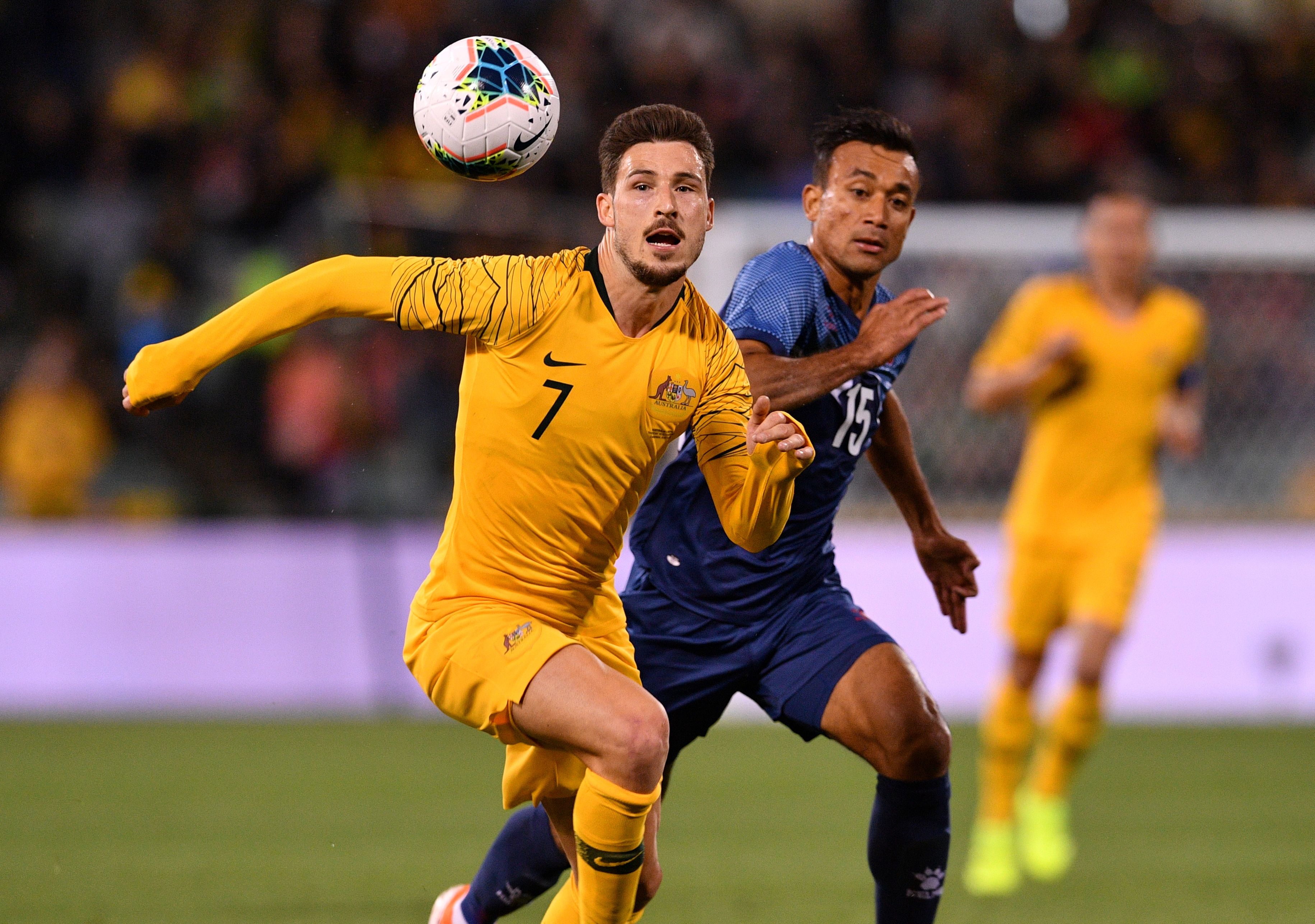 Pemain timnas Australia Mathew Leckie (kiri) mencoba menerima umpang bola dengan dibayangani pemain Nepal, Sujal Shrestha.