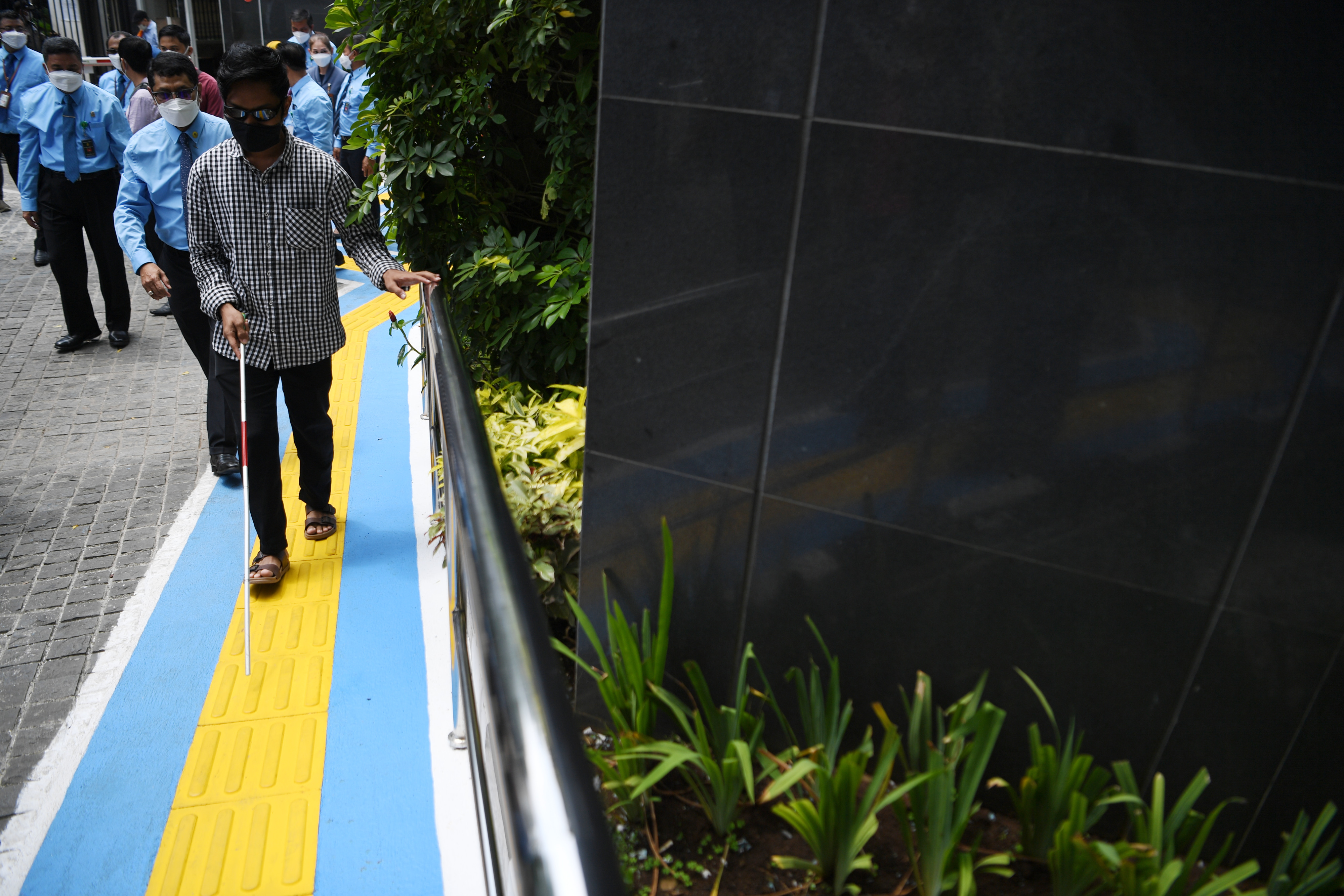 Penyandang tunanetra didampingi petugas berjalan di jalur pemandu di PN Jakarta Pusat, Jakarta. 