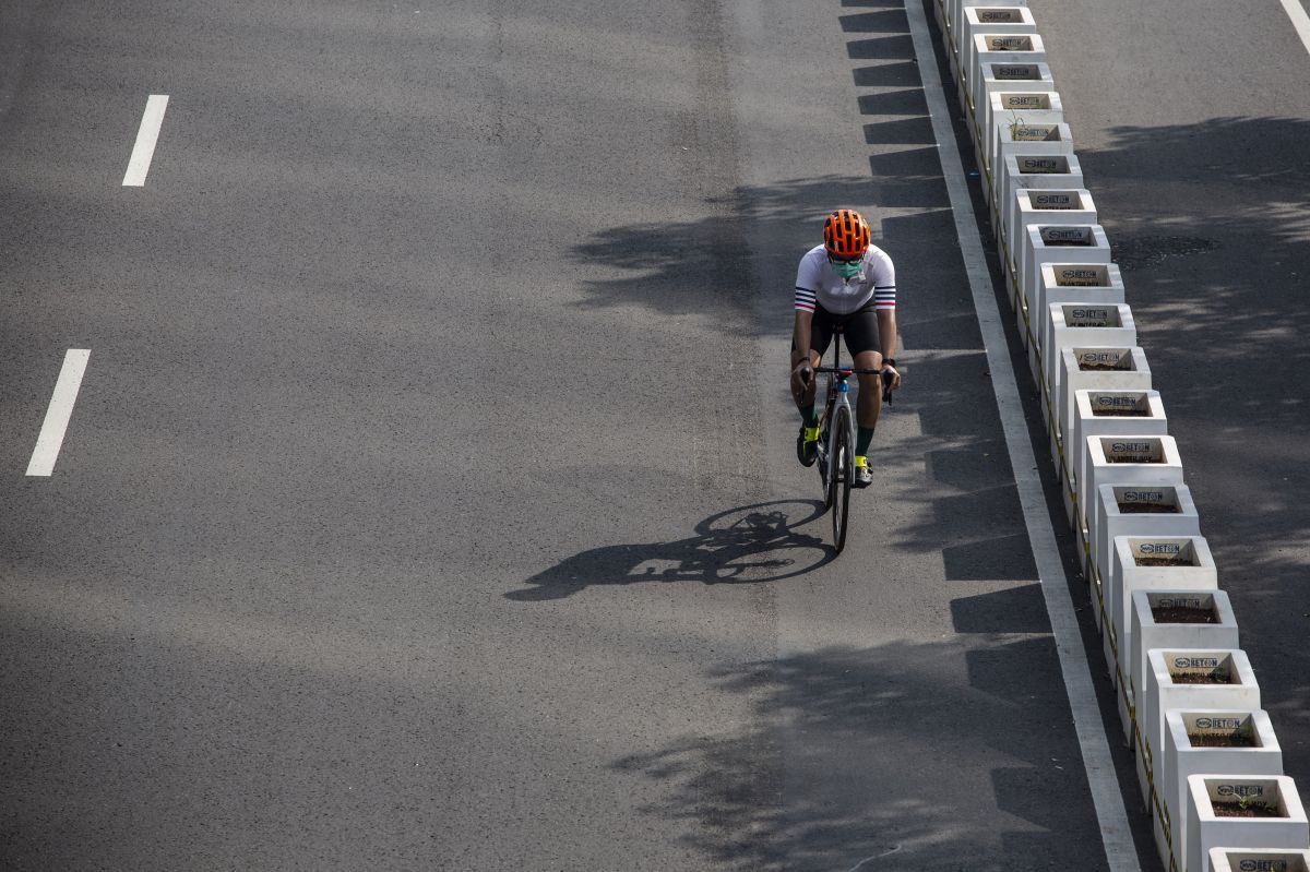Pesepeda memacu kecepatan saat melintas di Jalan Jenderal Sudirman, Jakarta. 