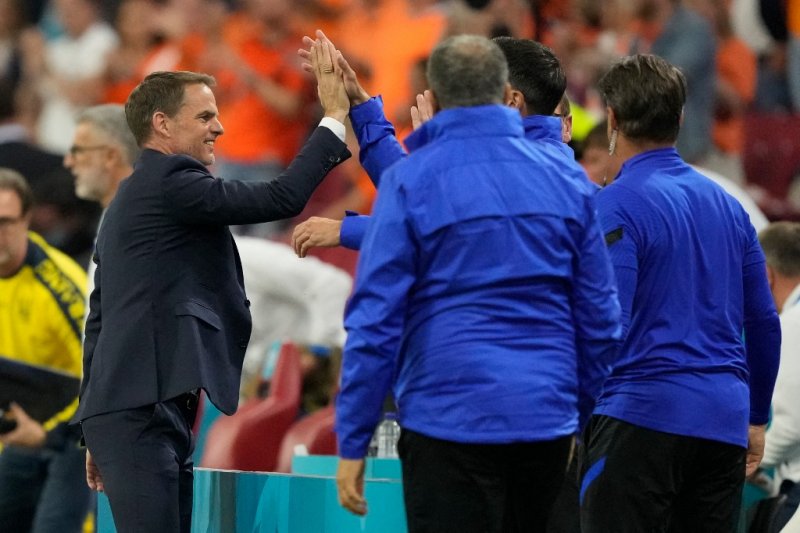 Pelatih Belanda Frank de Boer merayakan kemenangan timnya atas Ukraina bersama stafnya di Johan Cruyff Arena di Amsterdam, Minggu (13/6)