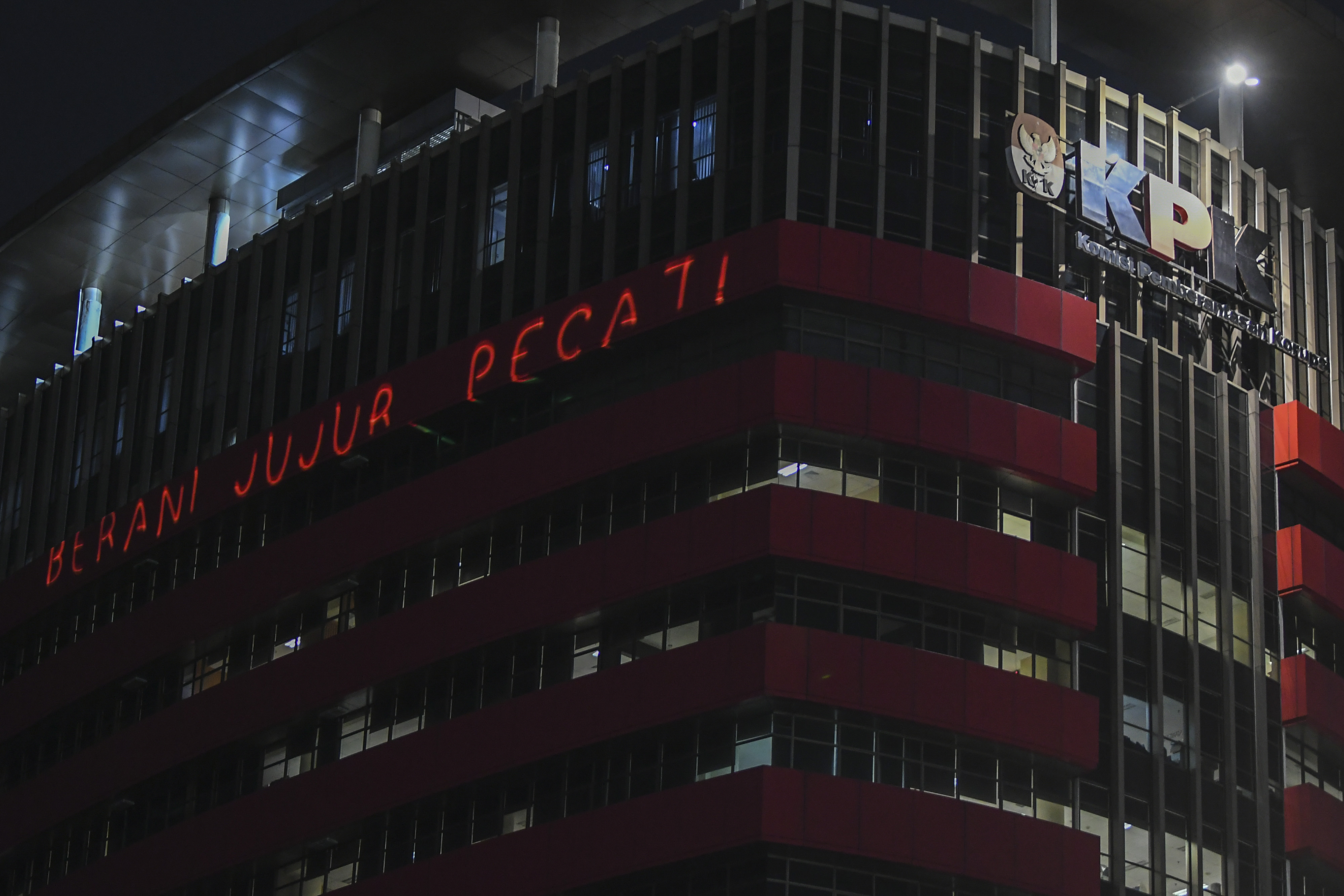 Aktivis Greenpeace menembakan sinar laser bertuliskan #BeraniJujurPecat saat menggelar aksi di Gedung KPK, Jakarta, Senin (28/6).