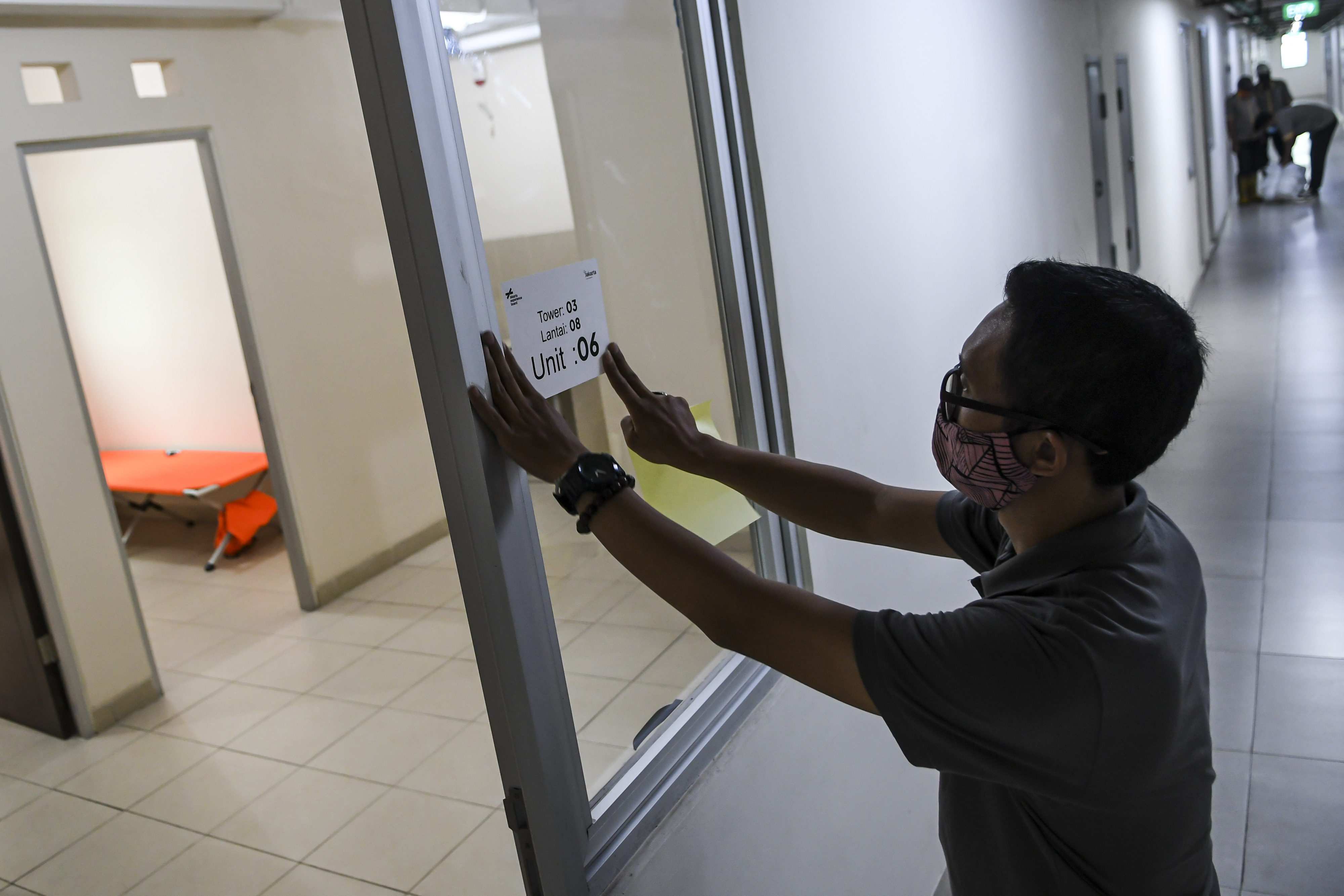 Petugas menempelkan stiker denah di salah satu tower Rusun Nagrak, Jakarta.