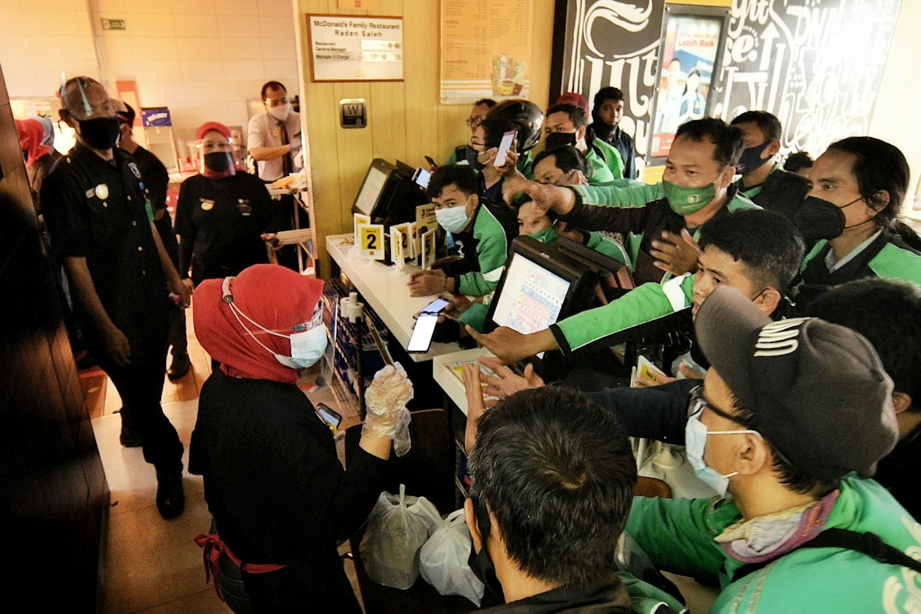 Pengemudi ojek online berkerumun untuk mengambil pesanan BTS Meal di gerai McDonald's.