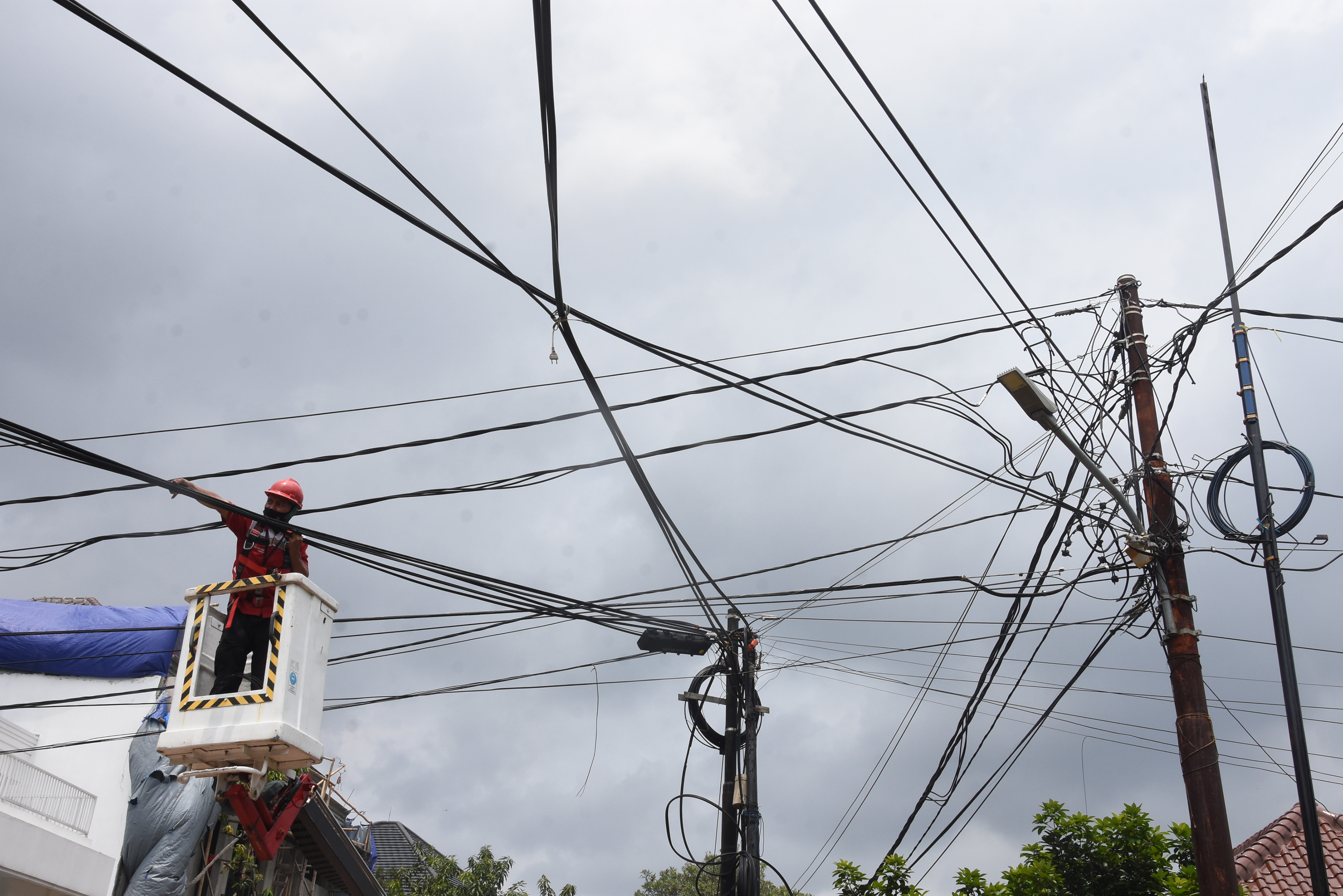 Seorang petugas tengah melakukan perawatan jaringan internet di sebuah perumahan di Jakarta.